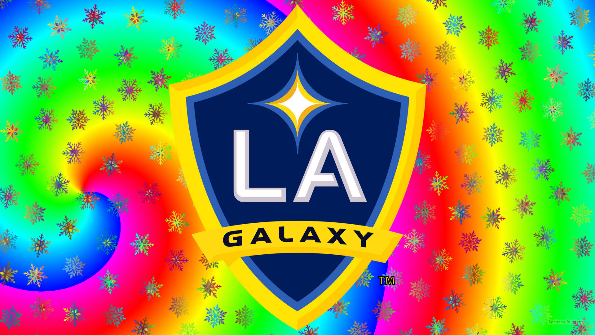 洛杉磯銀河彩色標誌 壁紙 — LA Galaxy 足球隊標誌居中放置於迷幻彩虹漩渦背景上，並帶有閃閃發光的雪花圖案。
