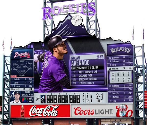 洛磯隊對戰勇士隊MLB比分 壁紙 — 身穿紫色球衣的棒球選手 Nolan Arenado 站在一個巨大的記分牌前，記分牌上顯示比賽統計數據和球隊標誌。