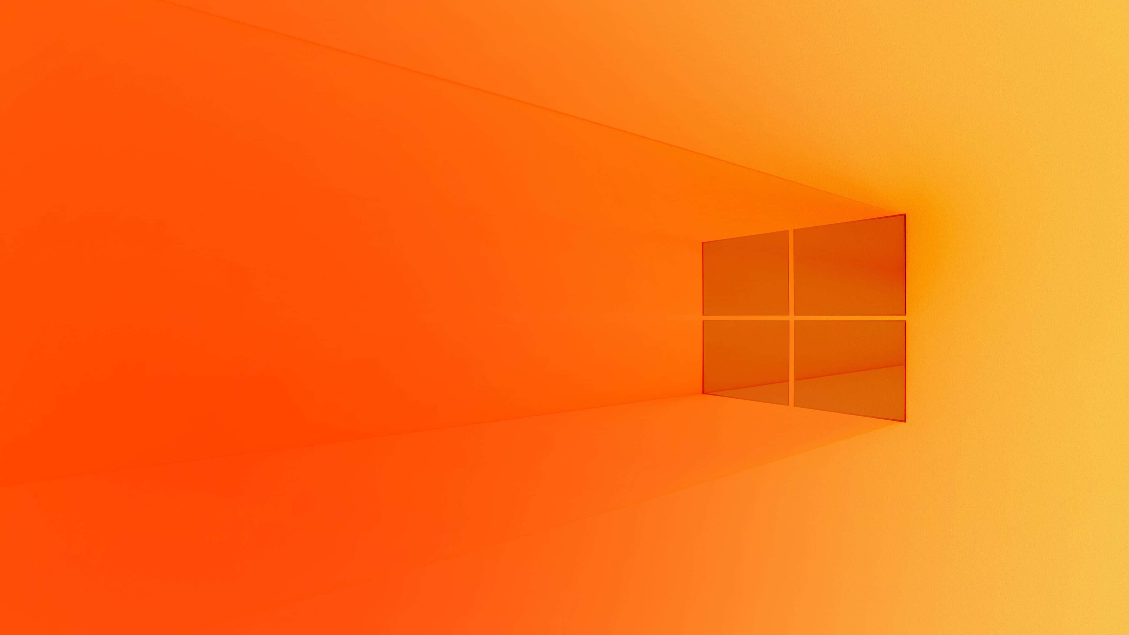 活力四射的 Windows 預設背景 壁紙 — 一個極簡主義的數碼藝術房間，沐浴在漸變橙色光線中，帶有Windows標誌窗戶投射出柔和陰影。