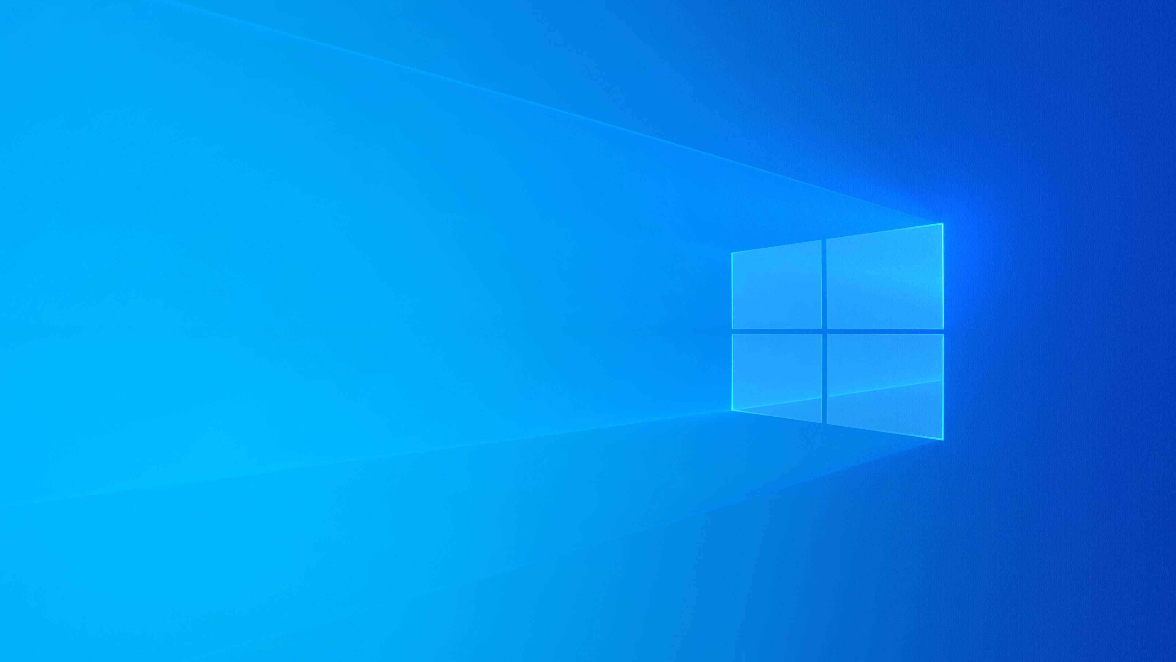 活力藍 Windows 10 高清 壁紙 — 一個發光的藍色窗戶標誌在漸變藍色背景上投射出柔和的光線。
