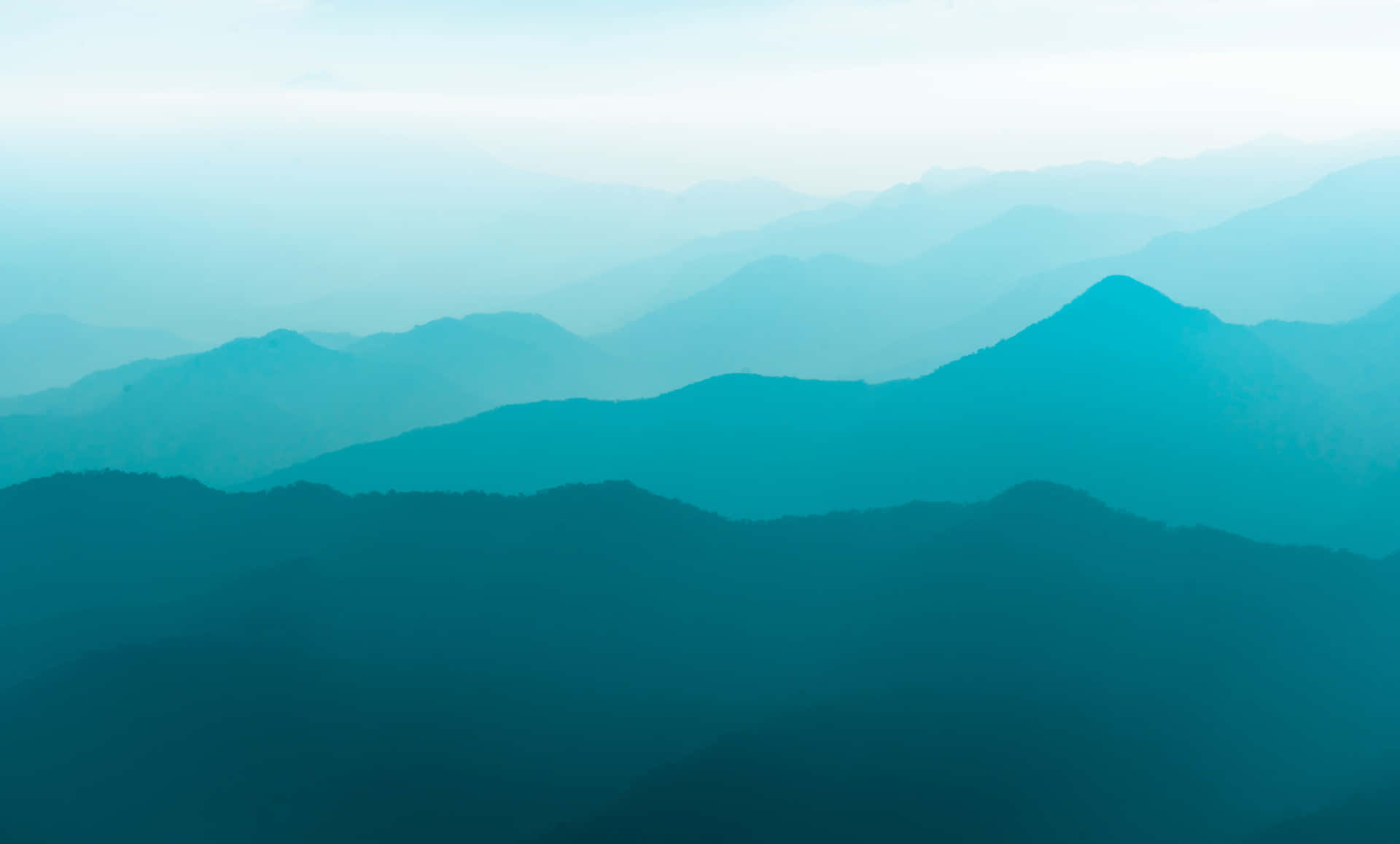 寧靜的山景，層疊的山峰在藍色薄霧中逐漸消失。