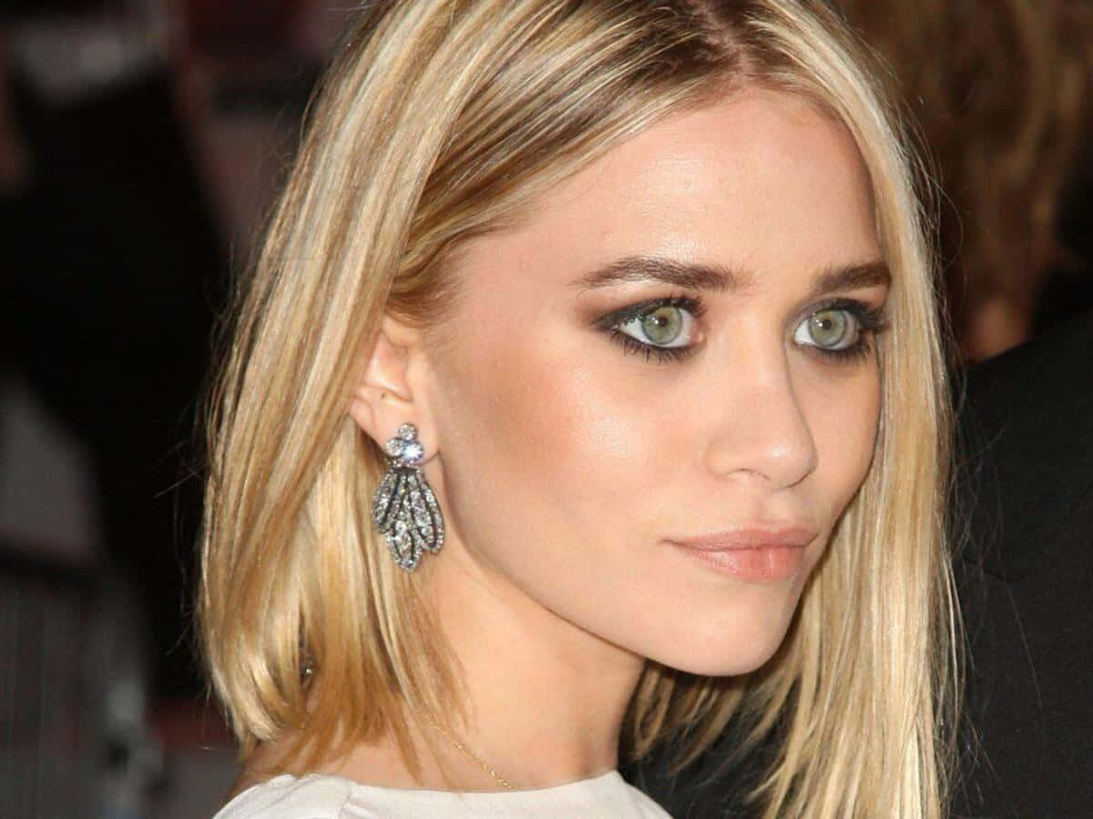 Mary Kate Olsen 桌布 壁紙 — 活動中一位金髮碧眼女子佩戴鑽石耳環的特寫肖像。