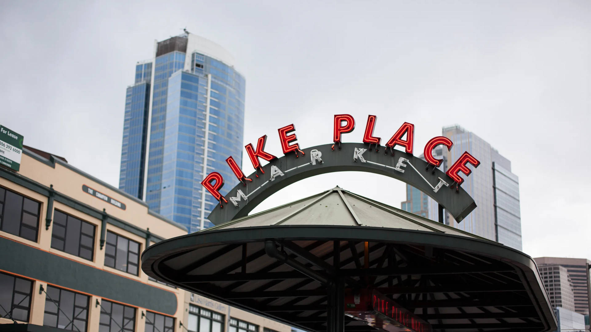 陰天下背景有玻璃塔的Pike Place Market標誌
