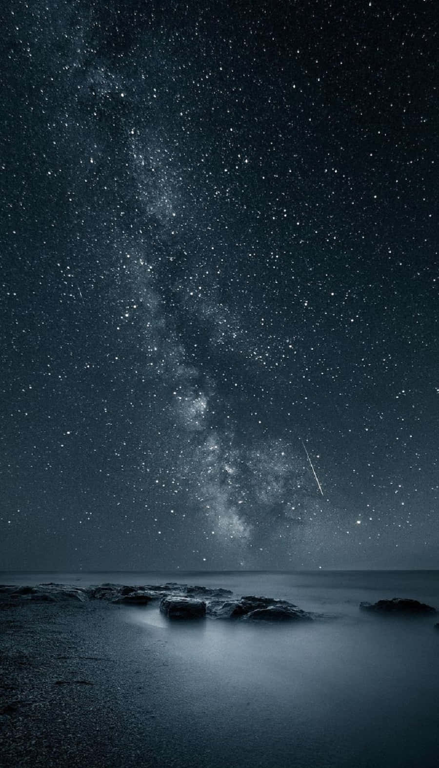 dreams 桌布 壁紙 — 流星下，銀河拱跨平靜海洋與岩石海岸的星空夜空。