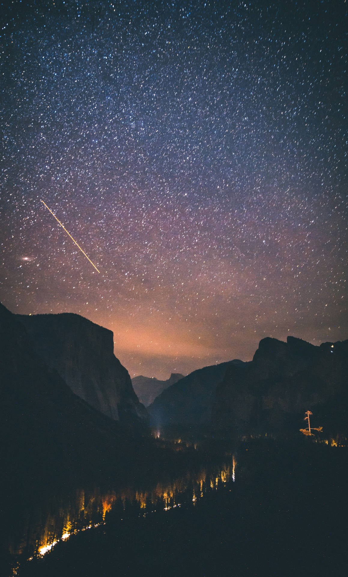 繁星點點的夜空，流星越過山脈和發光的河流