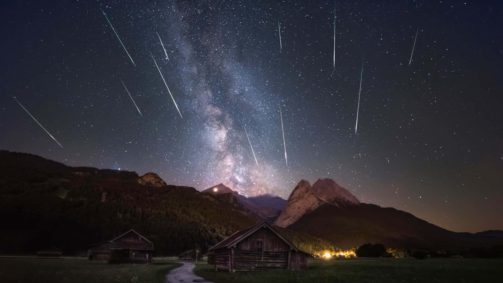 流星劃過繁星夜空 壁紙 — 流星軌跡劃過的星空之夜，拱形籠罩著山谷中的質樸木屋。