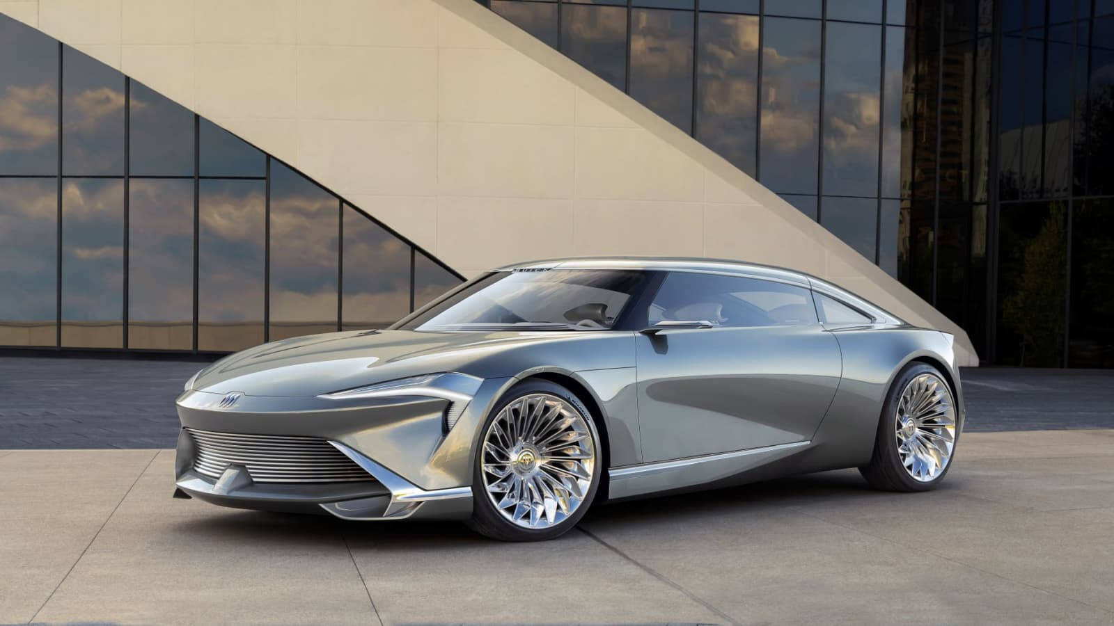 銀色未來主義跑車停在現代玻璃建築前。