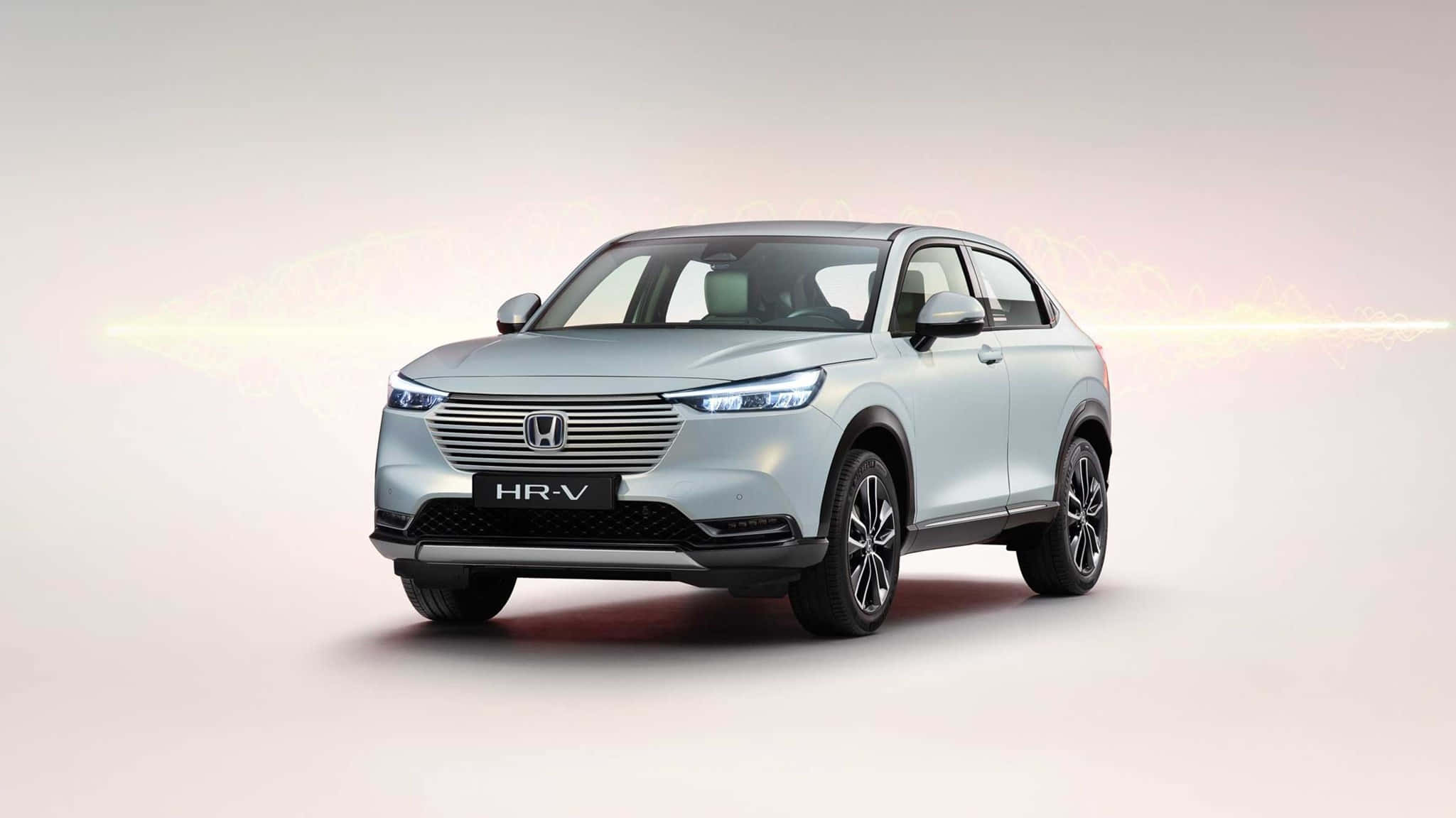 Honda Hr-v 桌布 壁紙 — 流線型銀色本田HR-V SUV在柔和漸變的攝影棚背景中展示，帶有發光的光條。