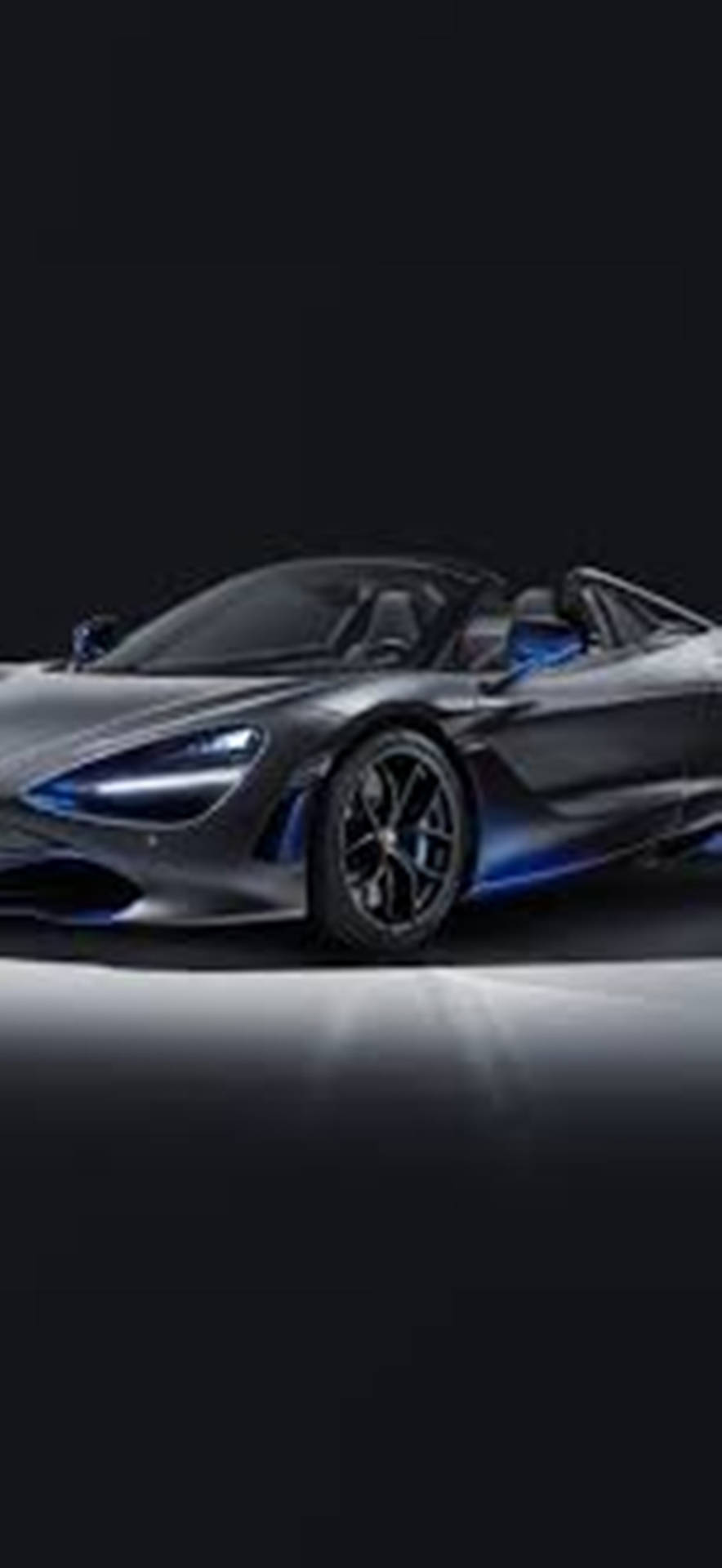 在黑暗的攝影棚環境中，時尚的銀色McLaren 720S Spider配以藍色燈光。
