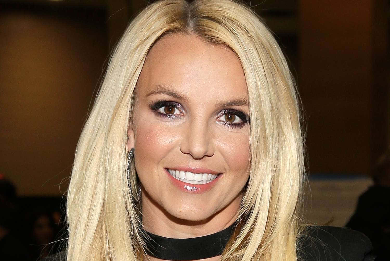 Britney Spears 微笑，金髮和黑色頸鏈。