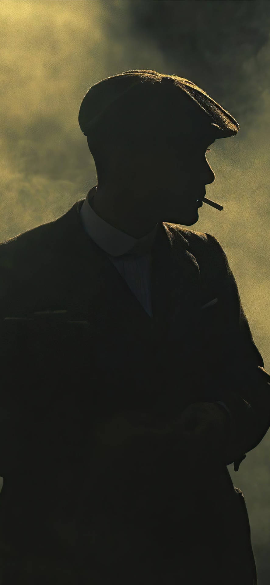 戴平頂帽男人在金色朦朧中抽煙剪影