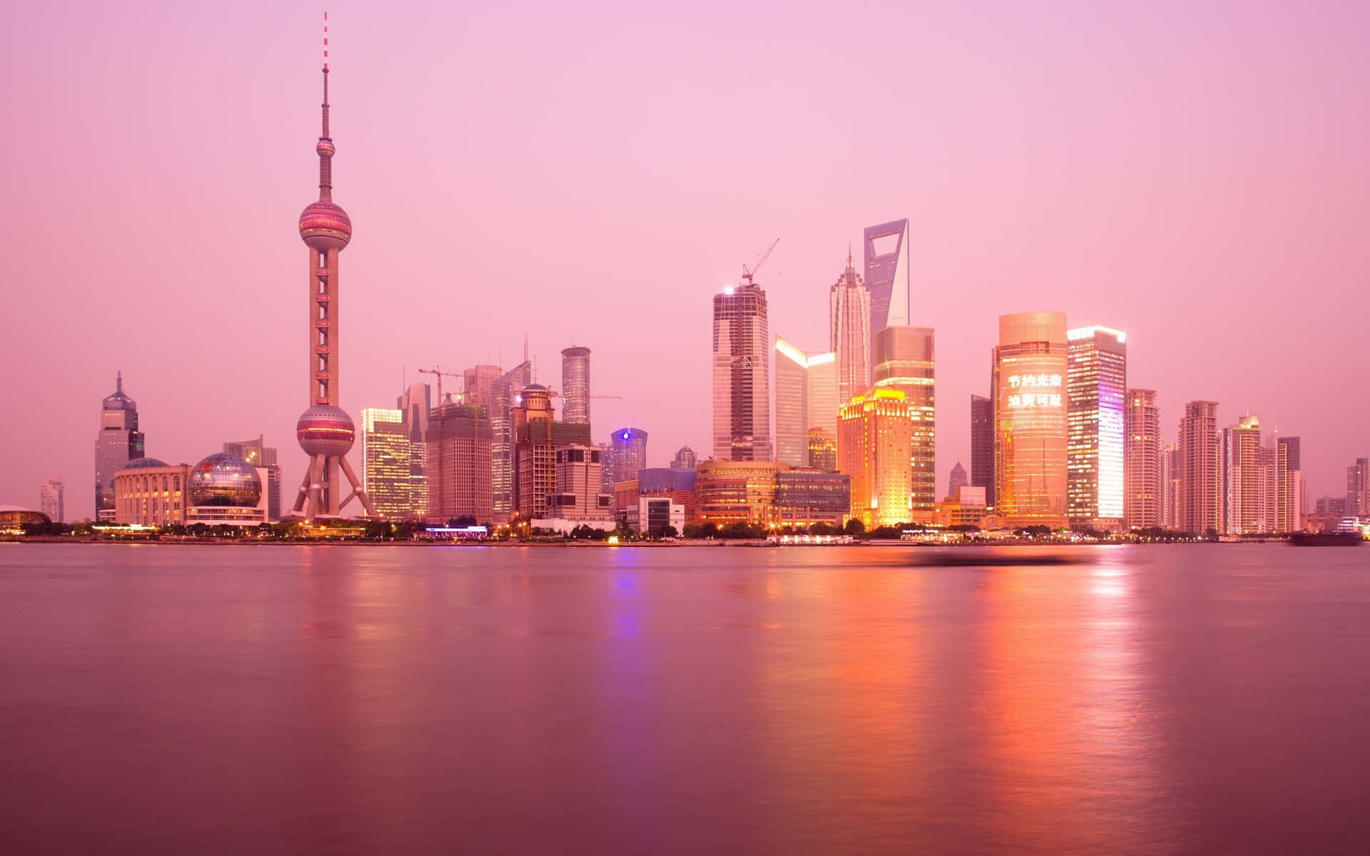 日落時分的上海天際線，粉紅色和橙色的色調倒映在水面上。 — 美景 壁紙