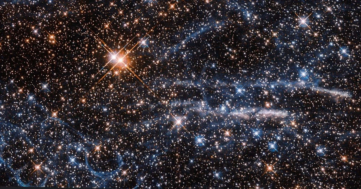 深邃太空中密集的星場和發光的藍色星雲。