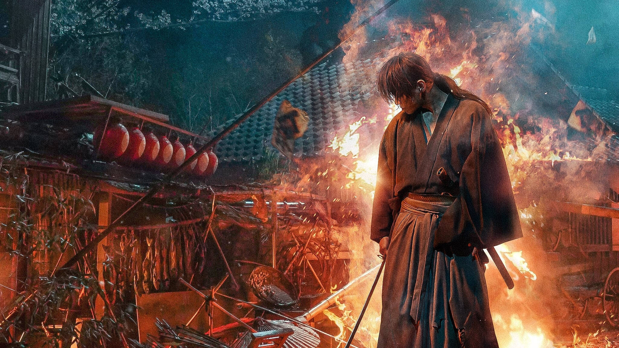 浪客劍心 燃燒屋前 壁紙 — 一位武士莊嚴地站在燃燒的村莊中，火焰吞噬著木結構建築，紅色燈籠懸掛在煙霧中。