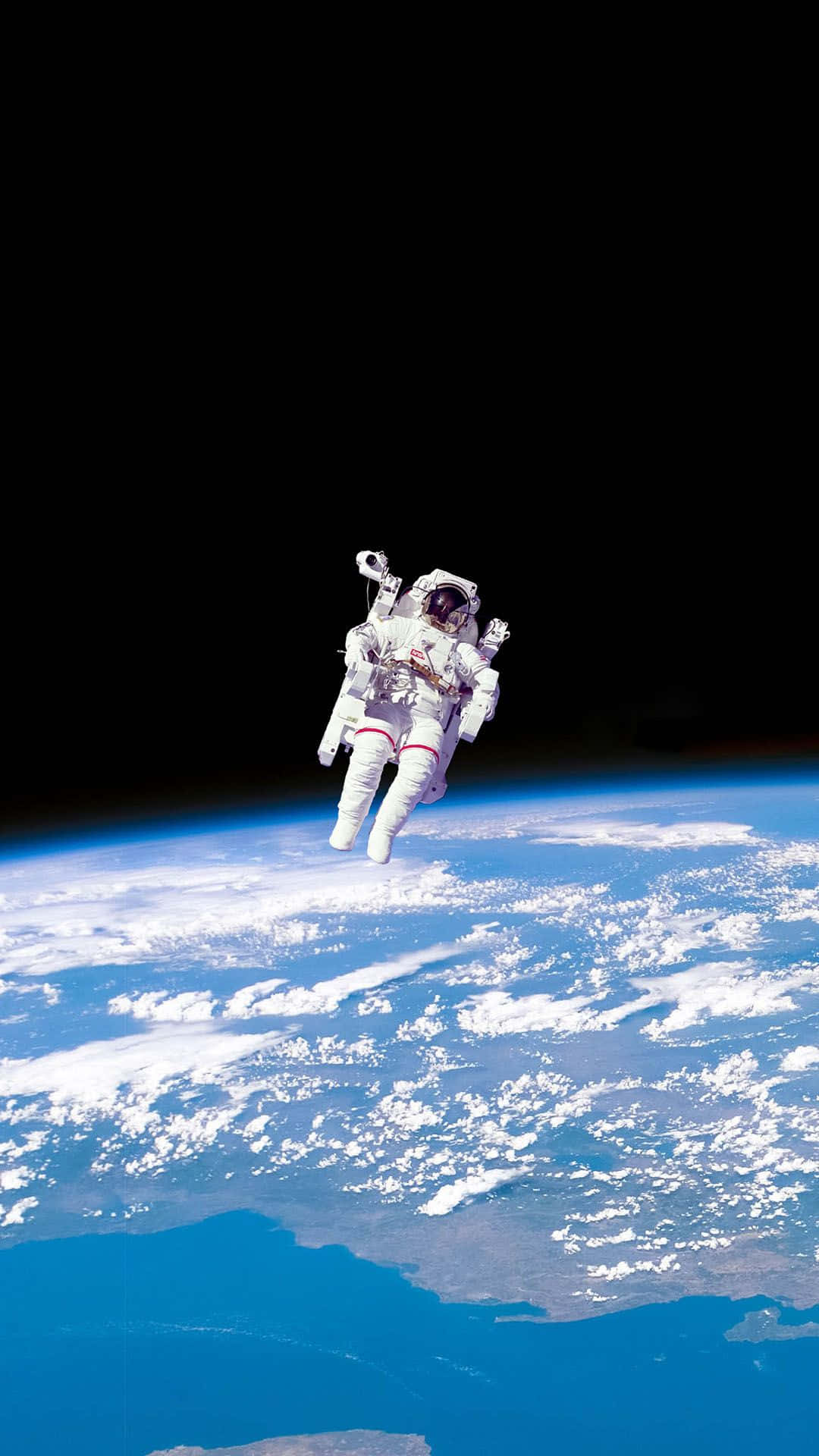 穿著太空衣的太空人漂浮在地球的藍色海洋和白色雲層之上。