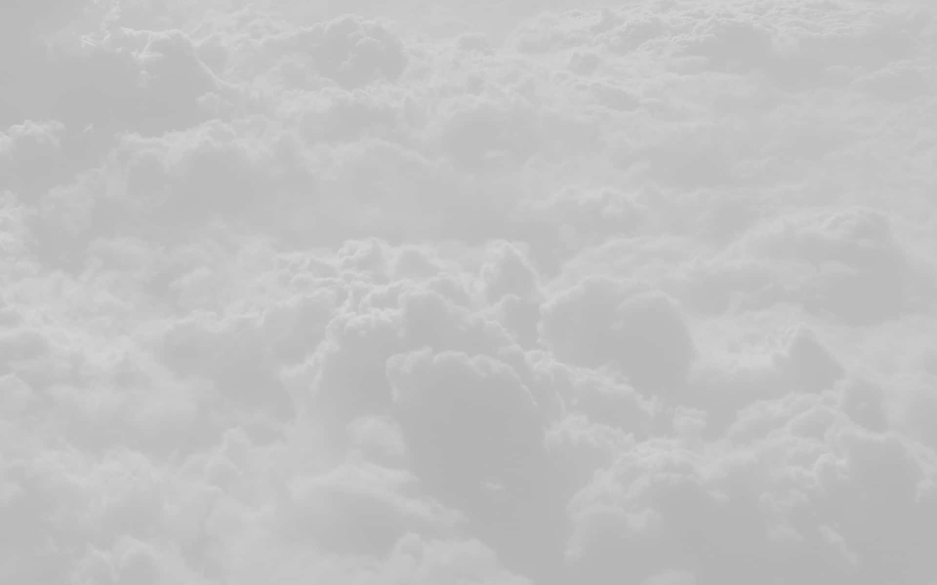 從上方俯瞰蓬鬆雲朵的寧靜景象，呈現柔和的灰色和白色調。