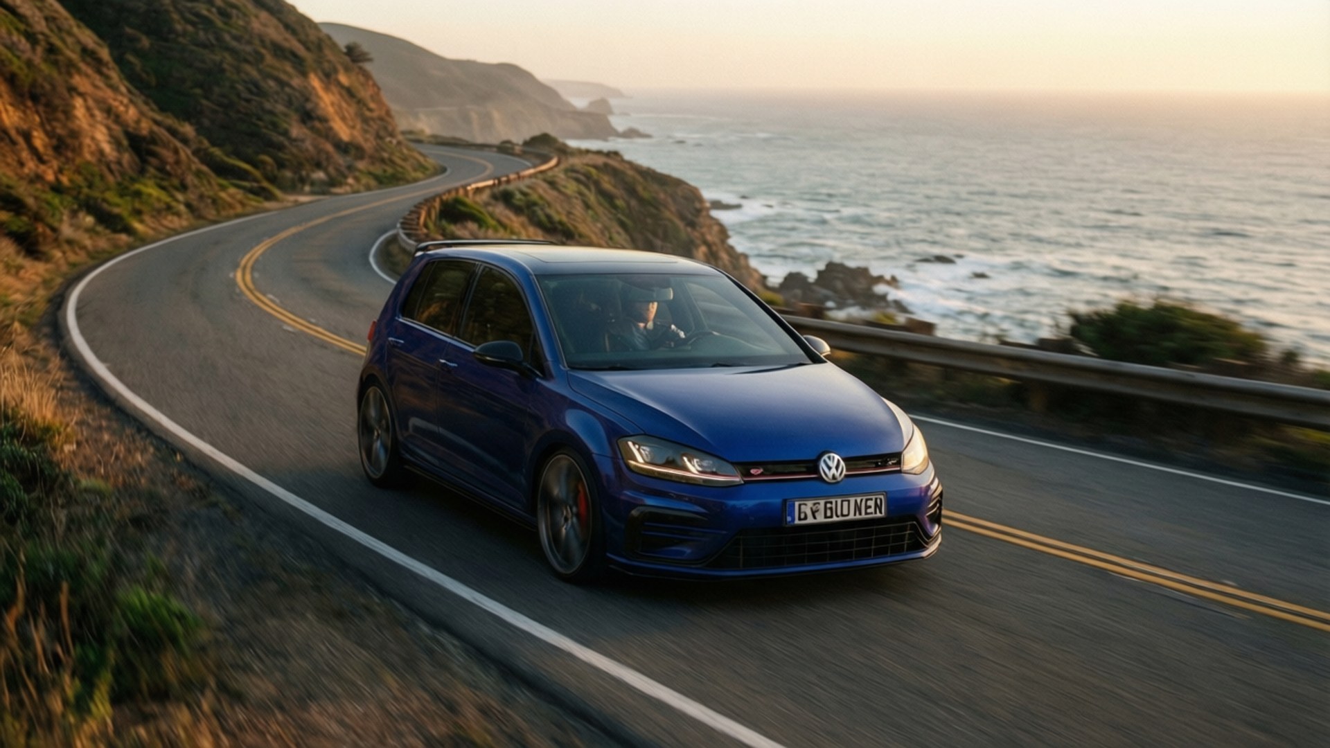 藍色Volkswagen Golf R在日落時分行駛在海岸公路上，享有海景