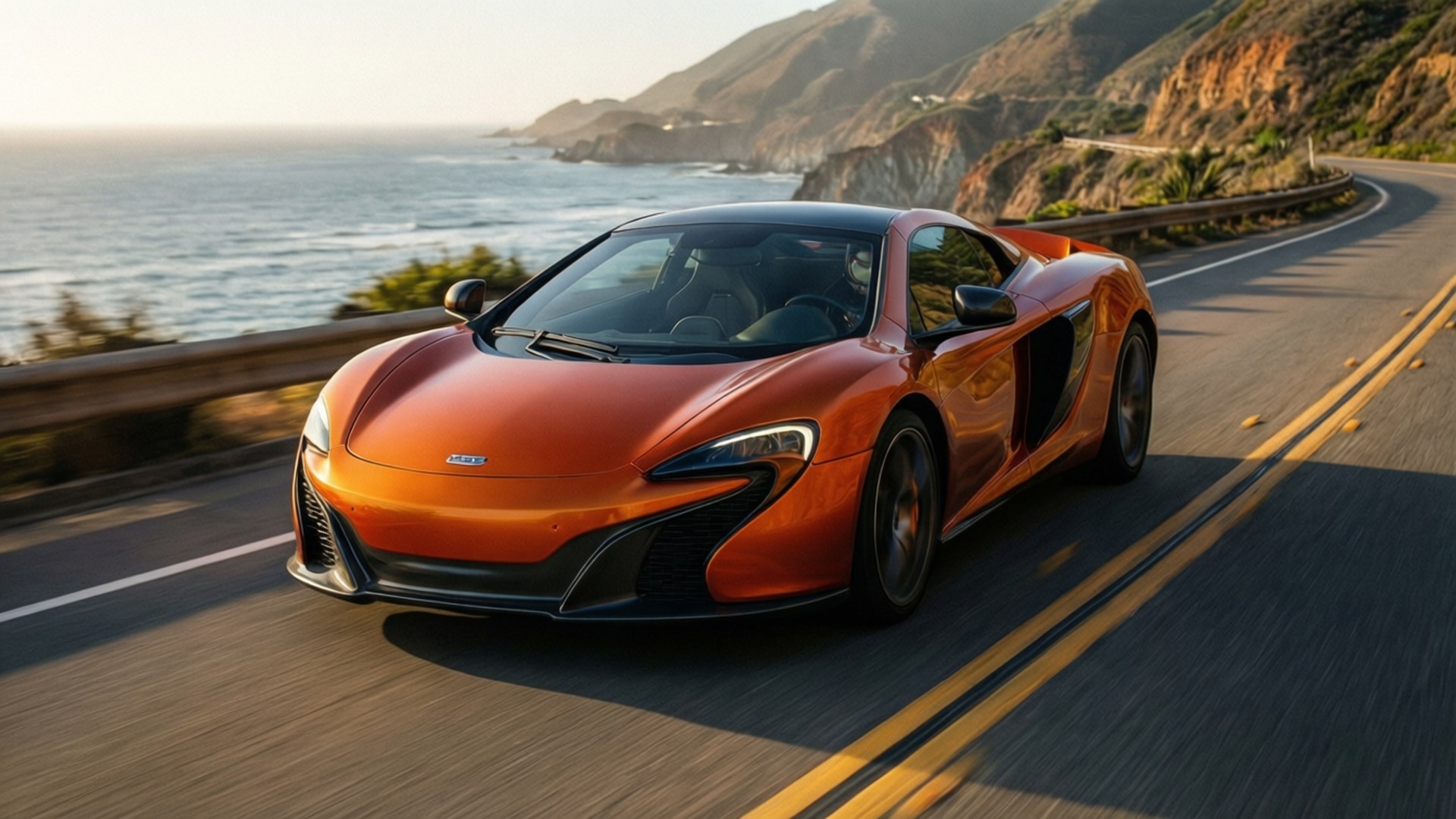 海岸速度 壁紙 — 一輛充滿活力的橙色McLaren跑車沿著海岸公路飛馳，背景是海洋懸崖和陽光普照的波浪。