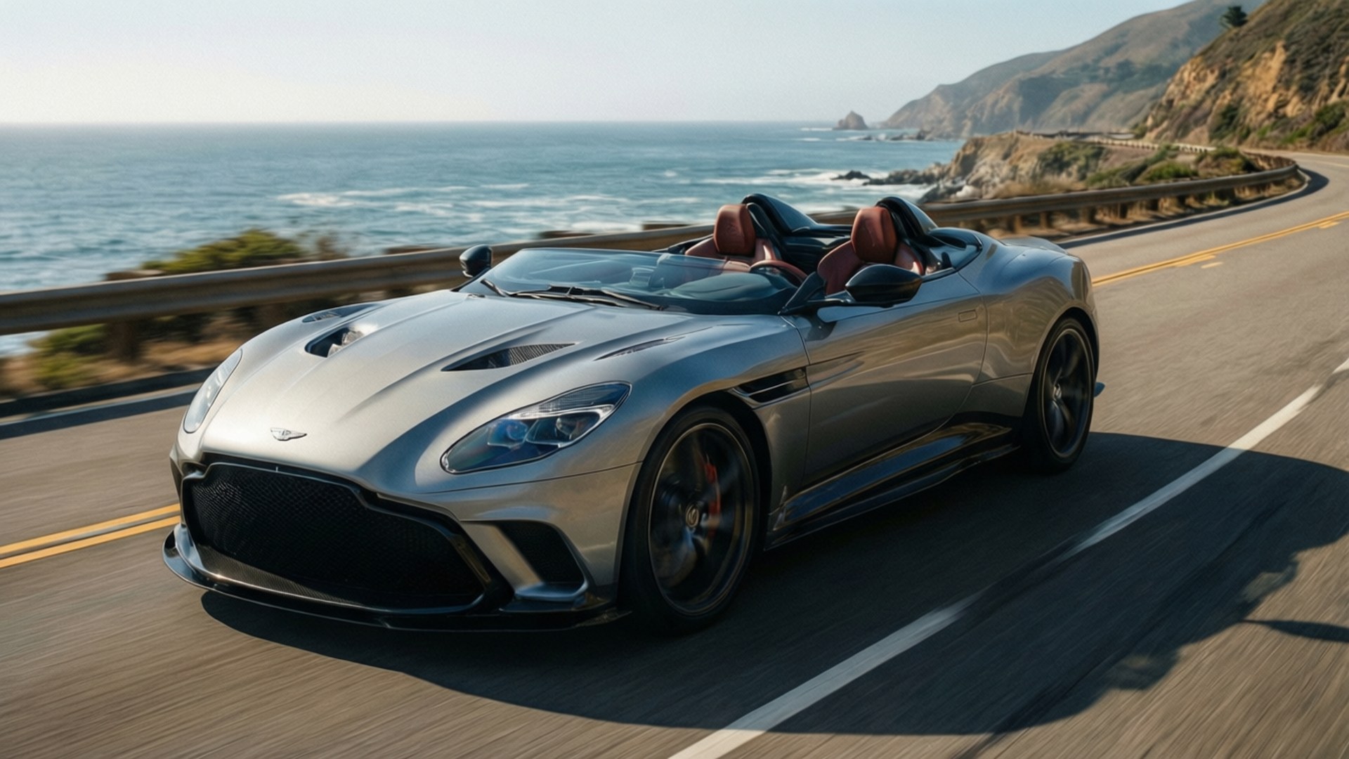 銀色Aston Martin開篷跑車在海岸高速公路上飛馳，背景有海洋和懸崖