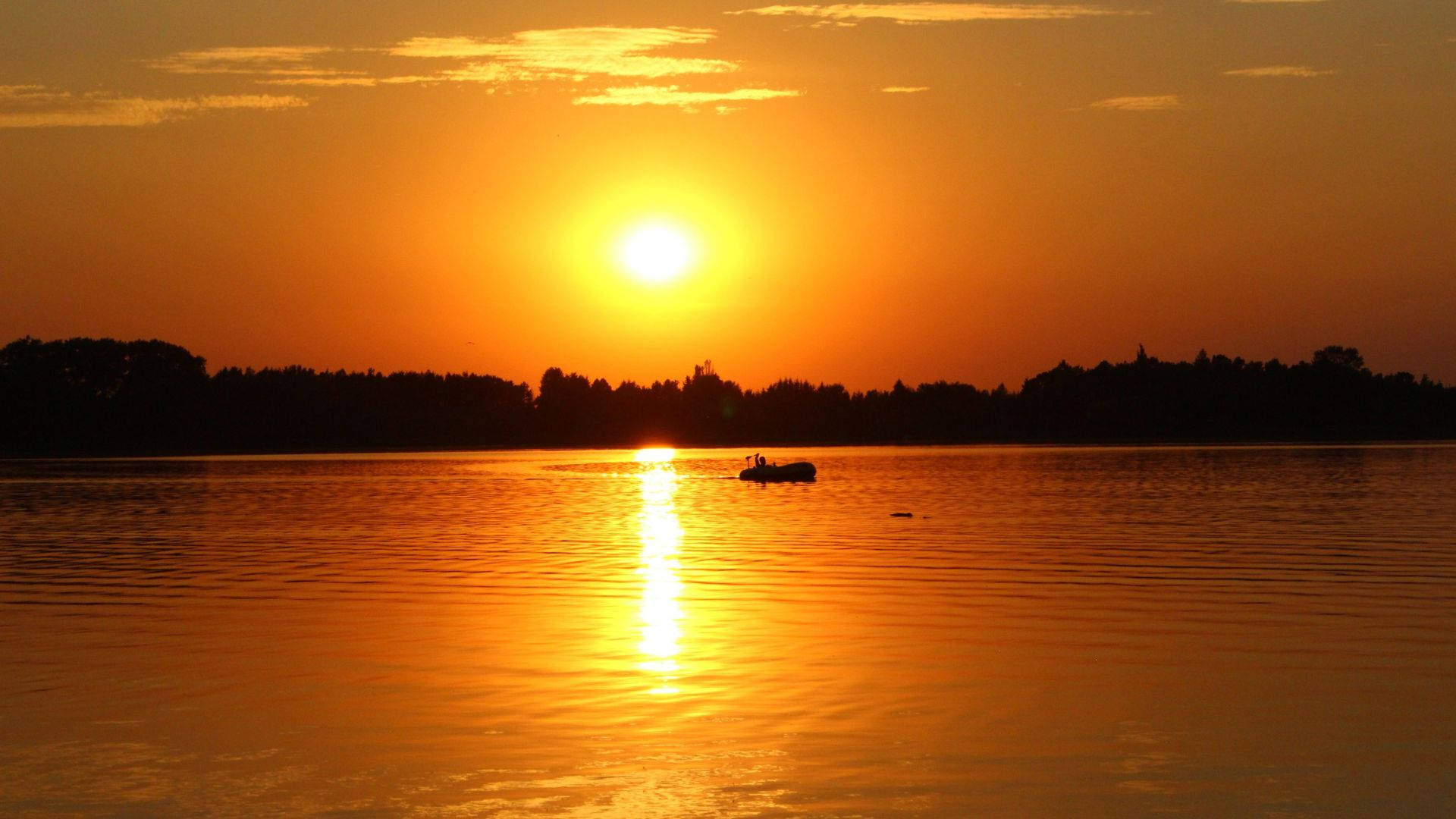 海景夕陽高溫 壁紙 — 一艘孤獨的小船在寧靜的湖面上滑行，夕陽如火般橙紅，在水面上投下閃爍的倒影。