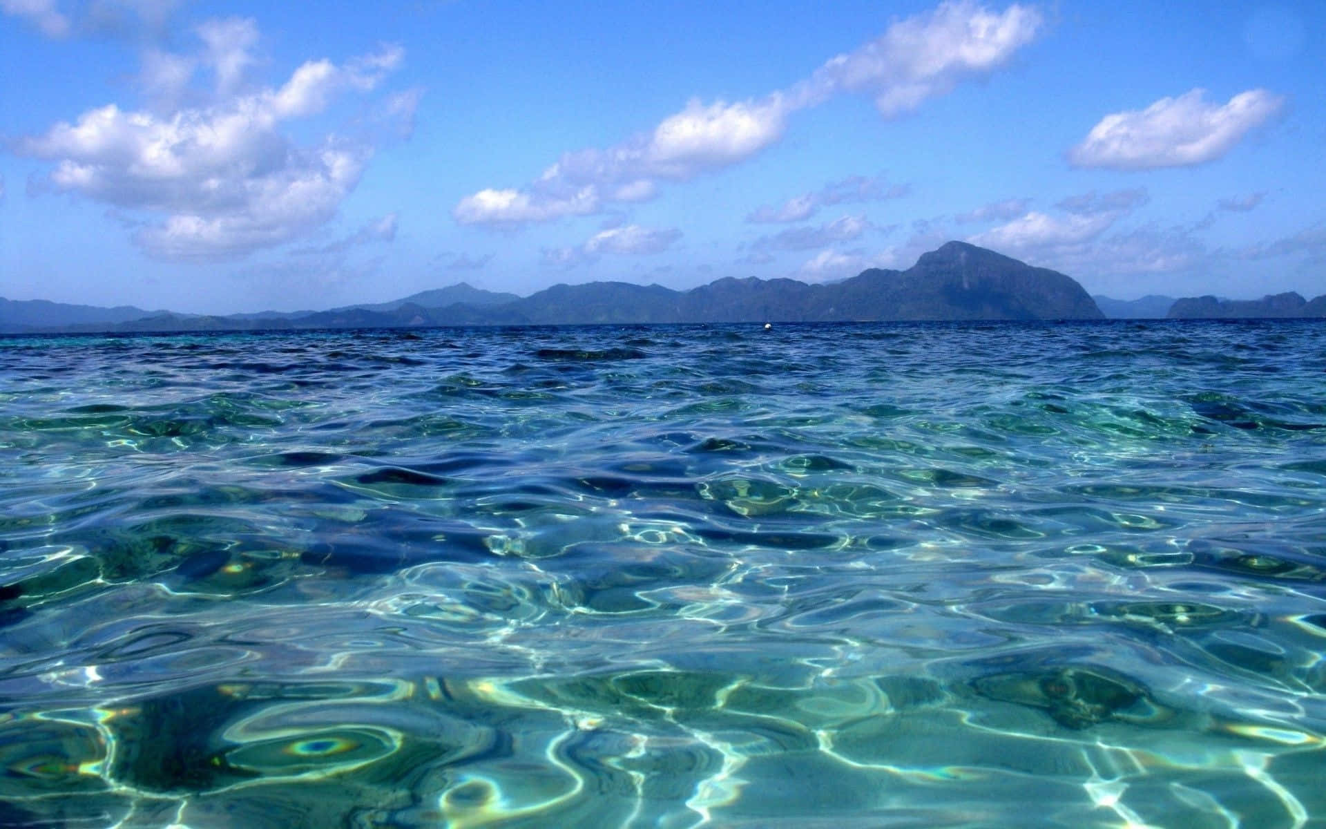清澈碧綠的海水，遠方島嶼，藍天白雲
