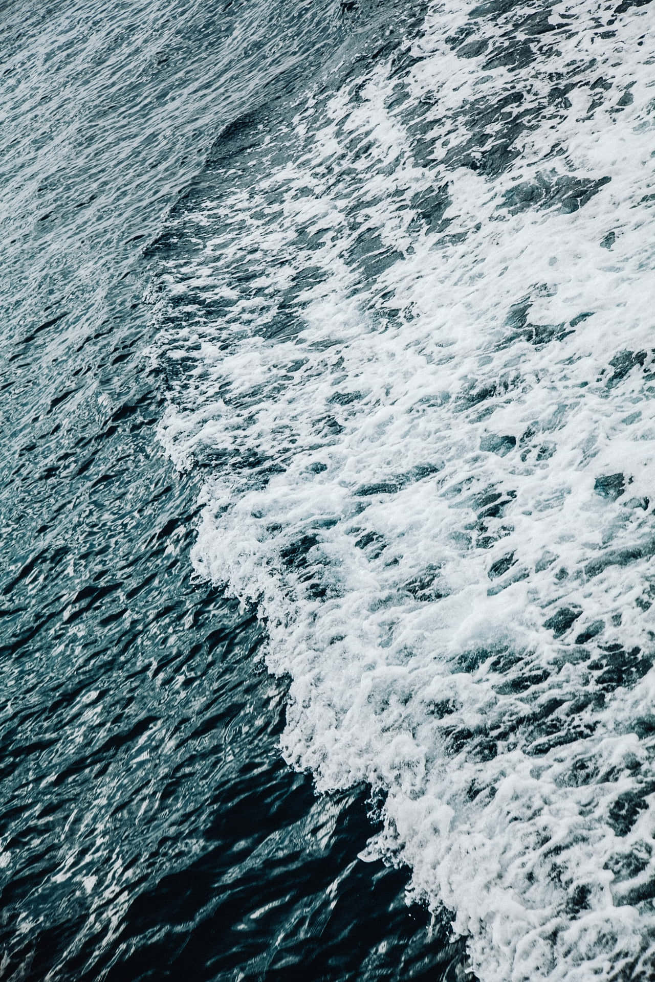 泡沫海浪拍打在深藍色水面上。