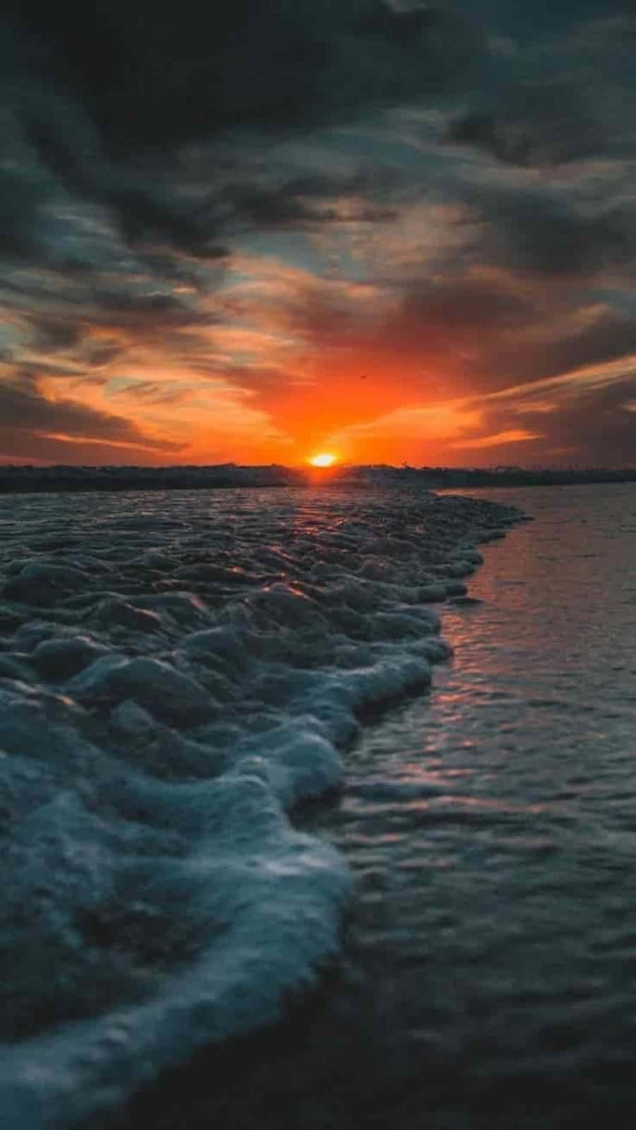 Sunset Photography 桌布 壁紙 — 海洋上空壯麗的日落，伴隨著火紅色的雲朵和泡沫般的波浪拍打著海岸。