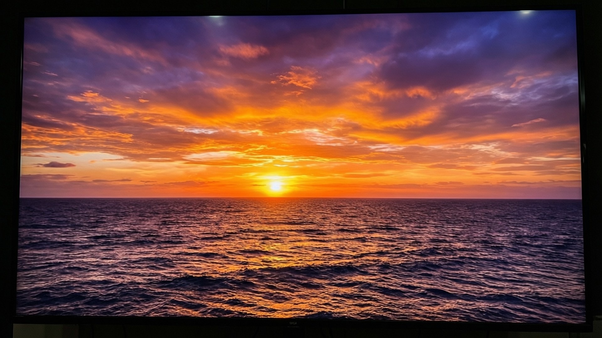 海洋上充滿活力的夕陽，橙色和紫色的雲彩倒映在水面上