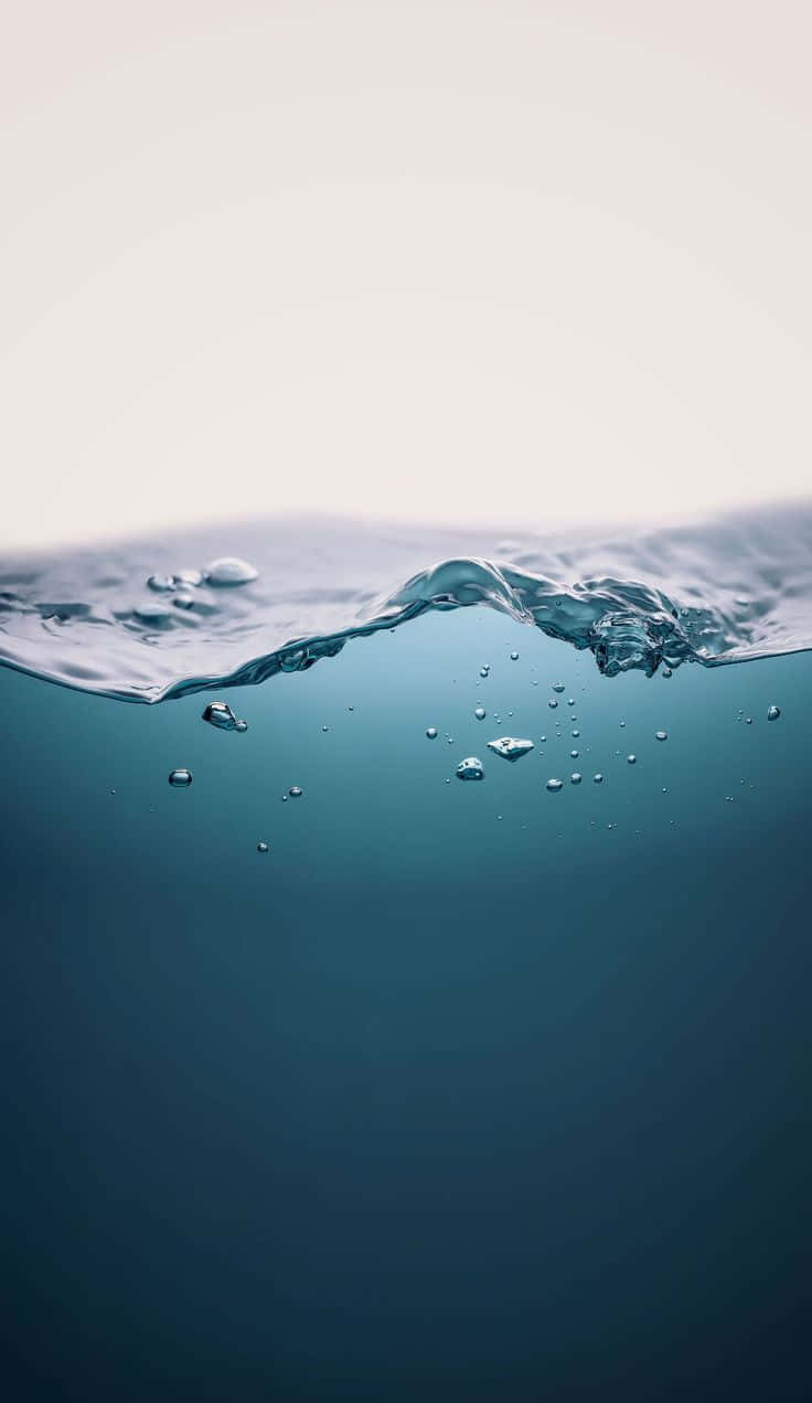 「海洋波浪的審美背景」 壁紙 — 柔和漫射光下，水面與水下分層的寧靜景象，帶有輕柔漣漪和氣泡。