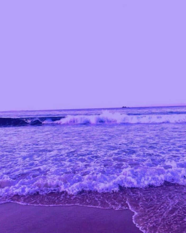 紫色海浪在日落時分湧上沙灘。
