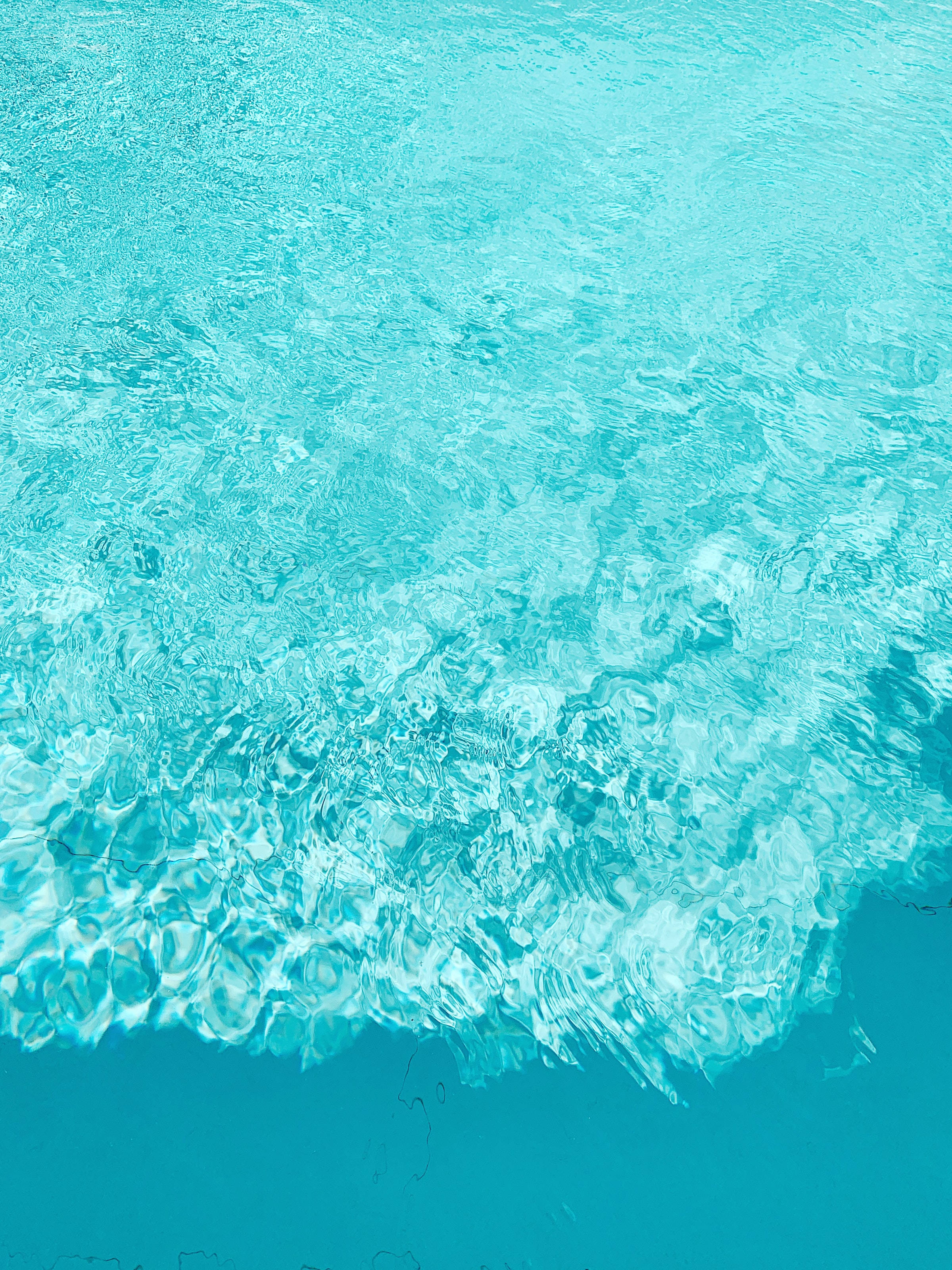 海洋藍色水花飛濺 壁紙 — Top-down view of turquoise pool water with rippling surface and light reflections.