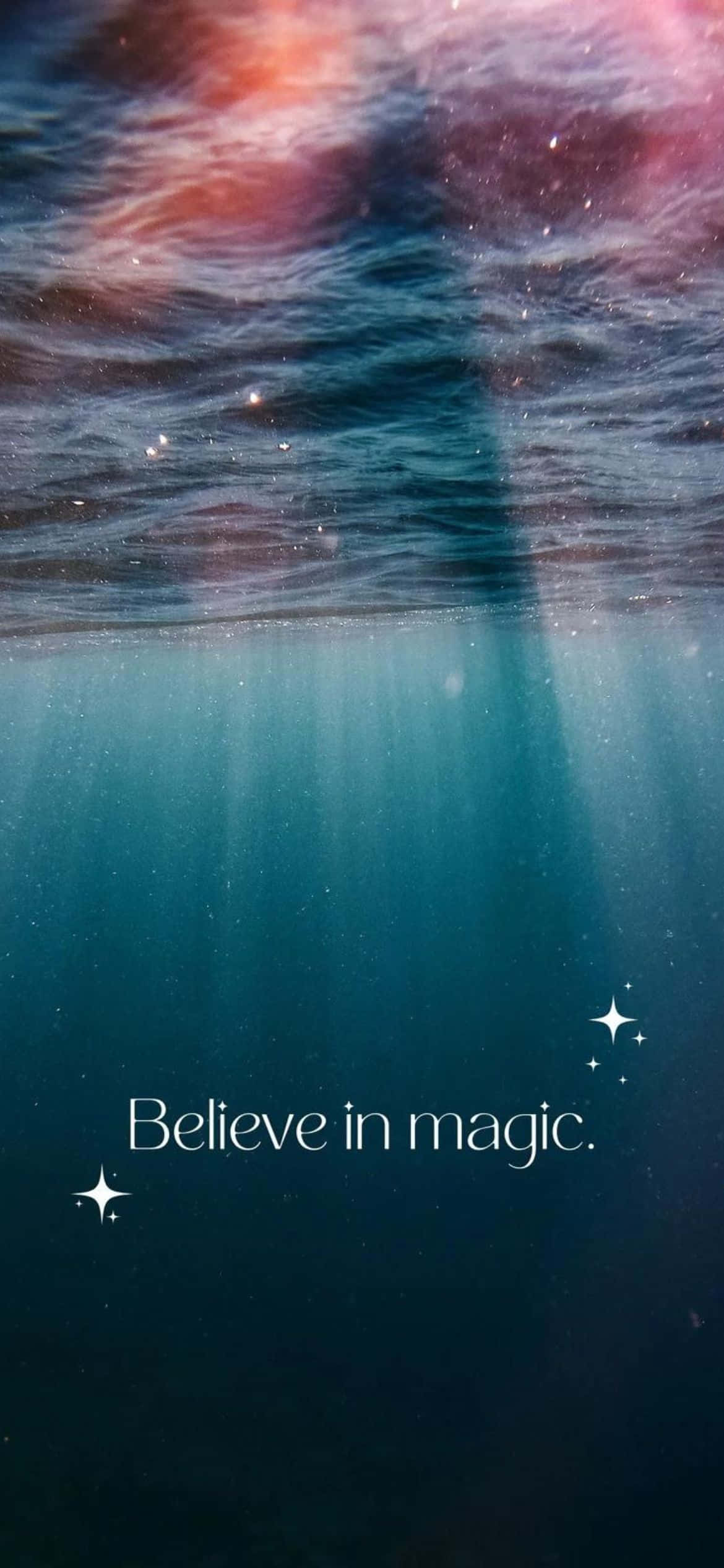 iPhone 13 Pro 桌布 壁紙 — 海洋表面的水下視圖，帶有星空倒影和文字believe in magic。