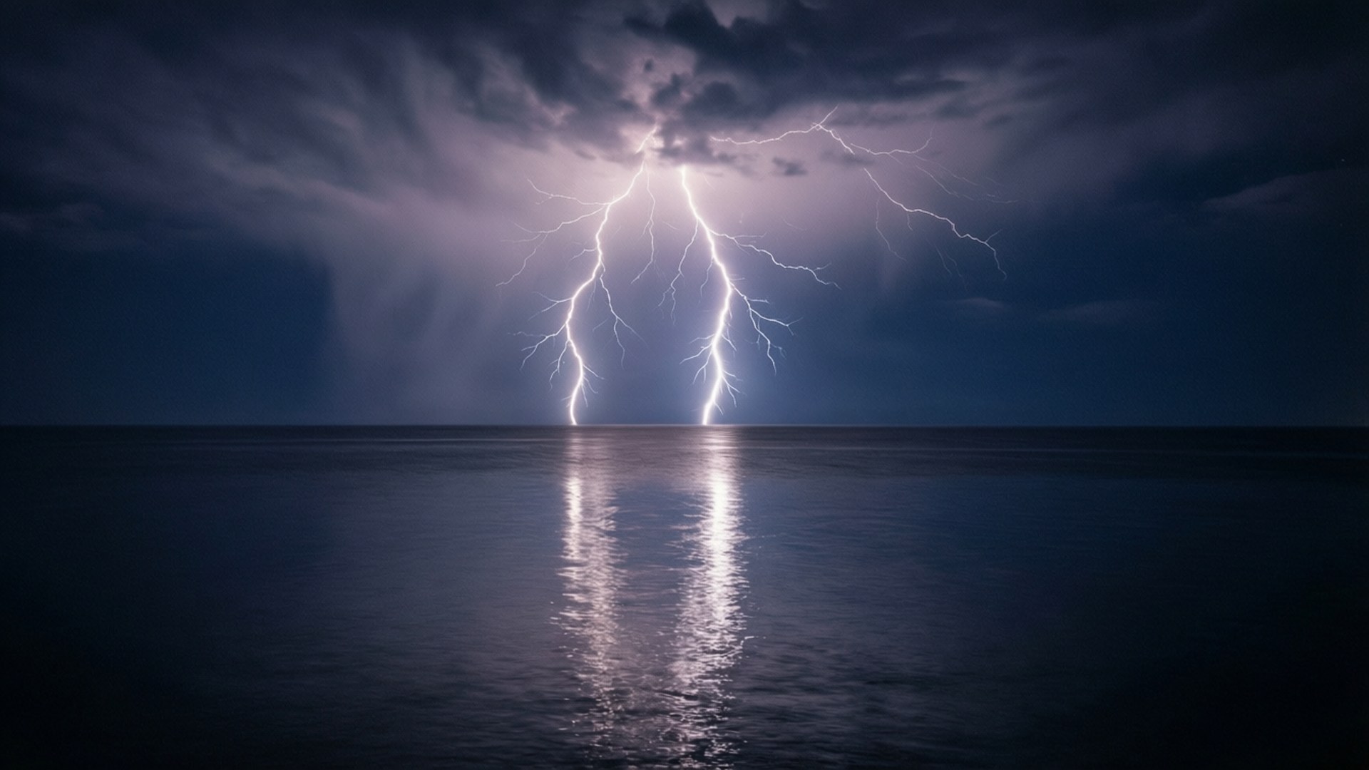 閃電在夜間擊中海洋，在水面上產生明亮的反射。