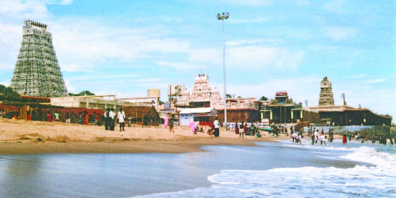 寺廟建築群位於擁擠的海灘上，海浪翻滾。