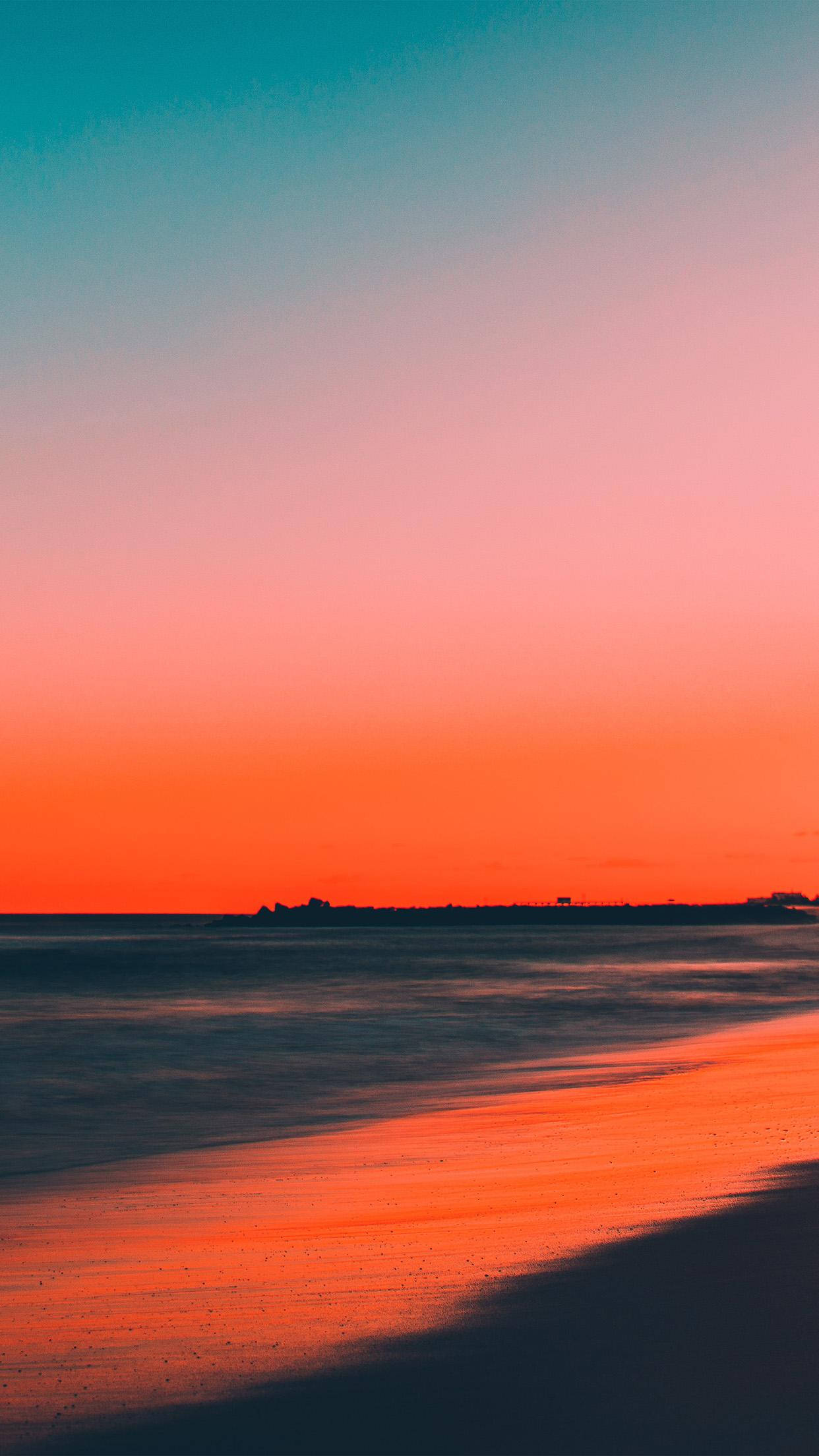 海灘上澄澈的日落天空 壁紙 — 日落時分的寧靜海灘，鮮豔的橙色和粉紅色天空映照在濕沙和靜止的水面上。