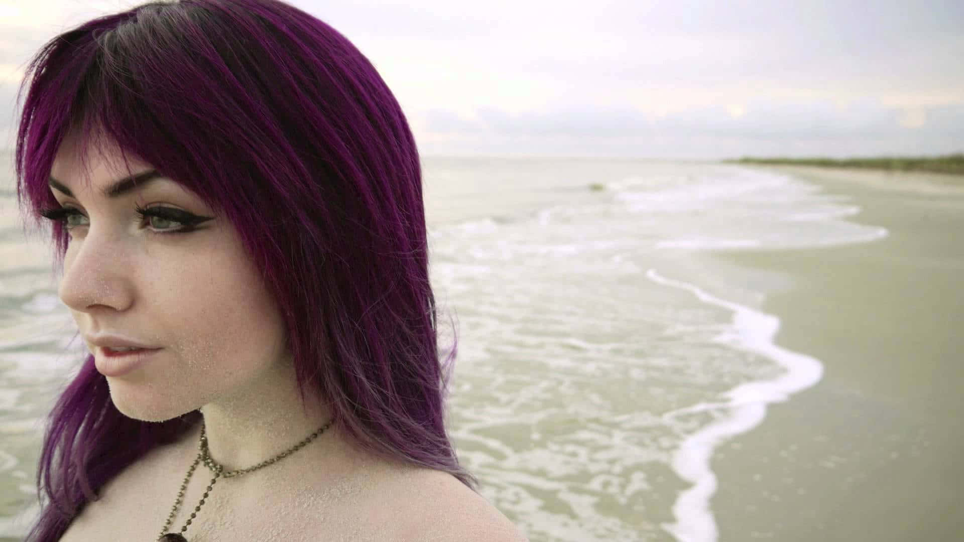 紫色頭髮女性在海灘上與海浪