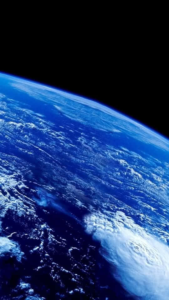 海灘上的美麗日落 壁紙 — 從太空俯瞰地球的壯麗景色，展現出旋轉的藍色海洋、白雲和巨大的颶風。