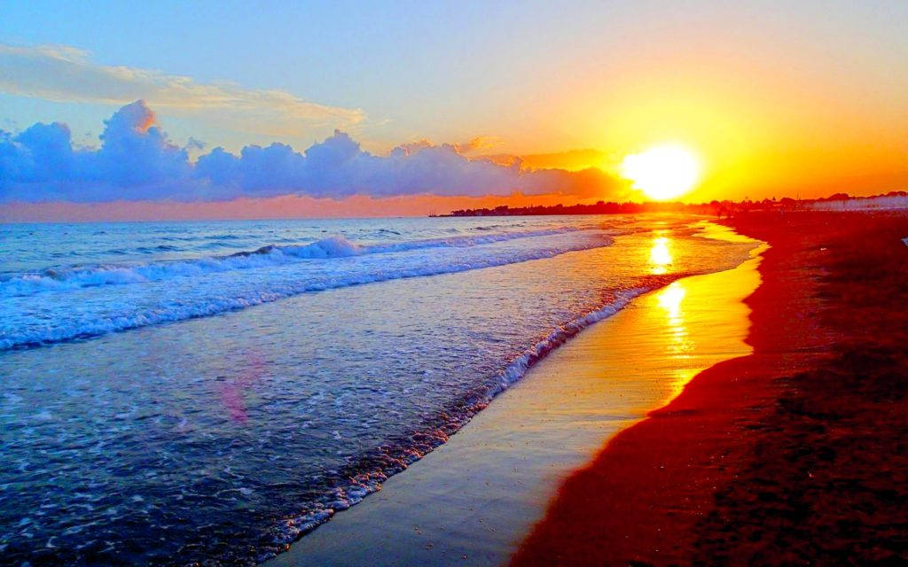海洋上的夕陽，海浪沖刷著沙灘