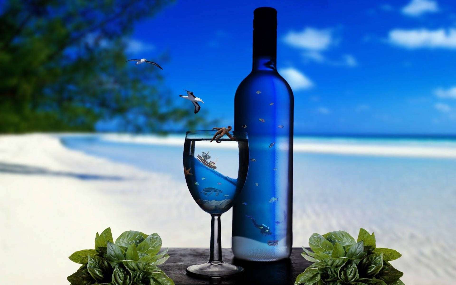 藍色酒瓶和酒杯，裡面有海洋場景，放在沙灘桌上，有綠葉。