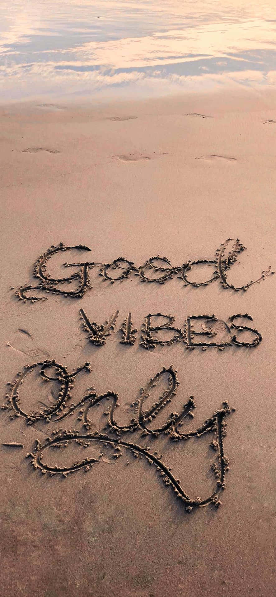 Good Vibes Only 用貝殼寫在日落時濕潤的沙灘上