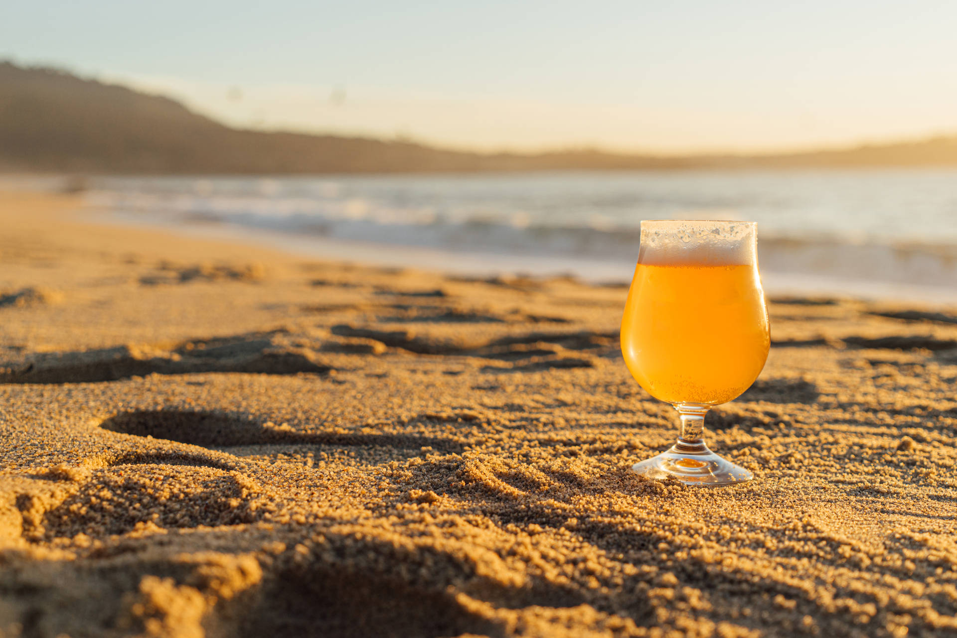 沙灘上的啤酒杯，金色夕陽與海浪