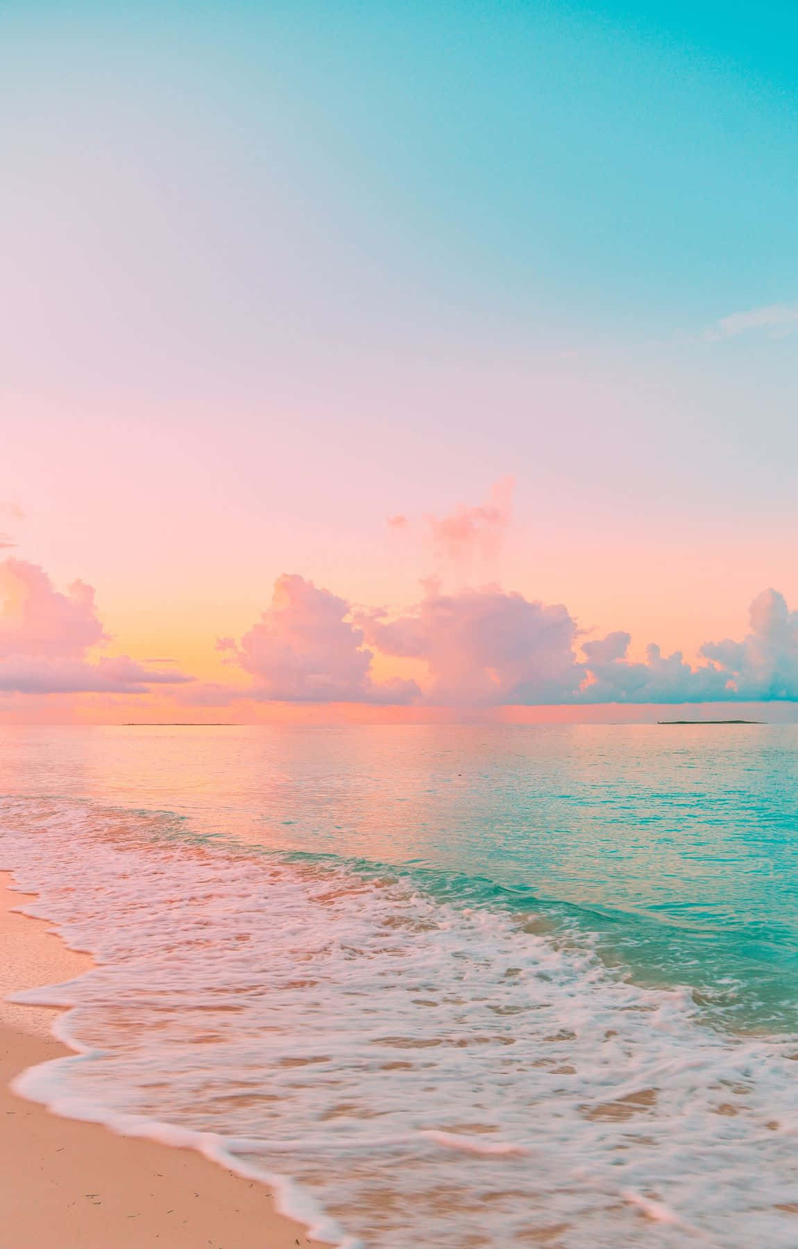 海洋上的粉彩日落，沙灘上有輕柔的波浪