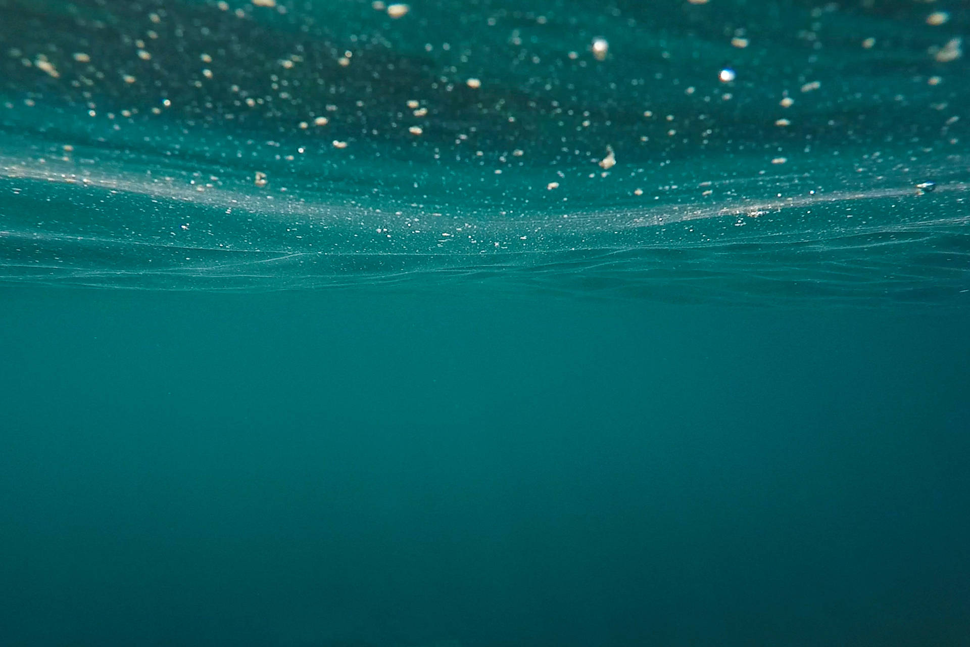 海底場景，藍綠色海水和靠近水面的浮動氣泡。