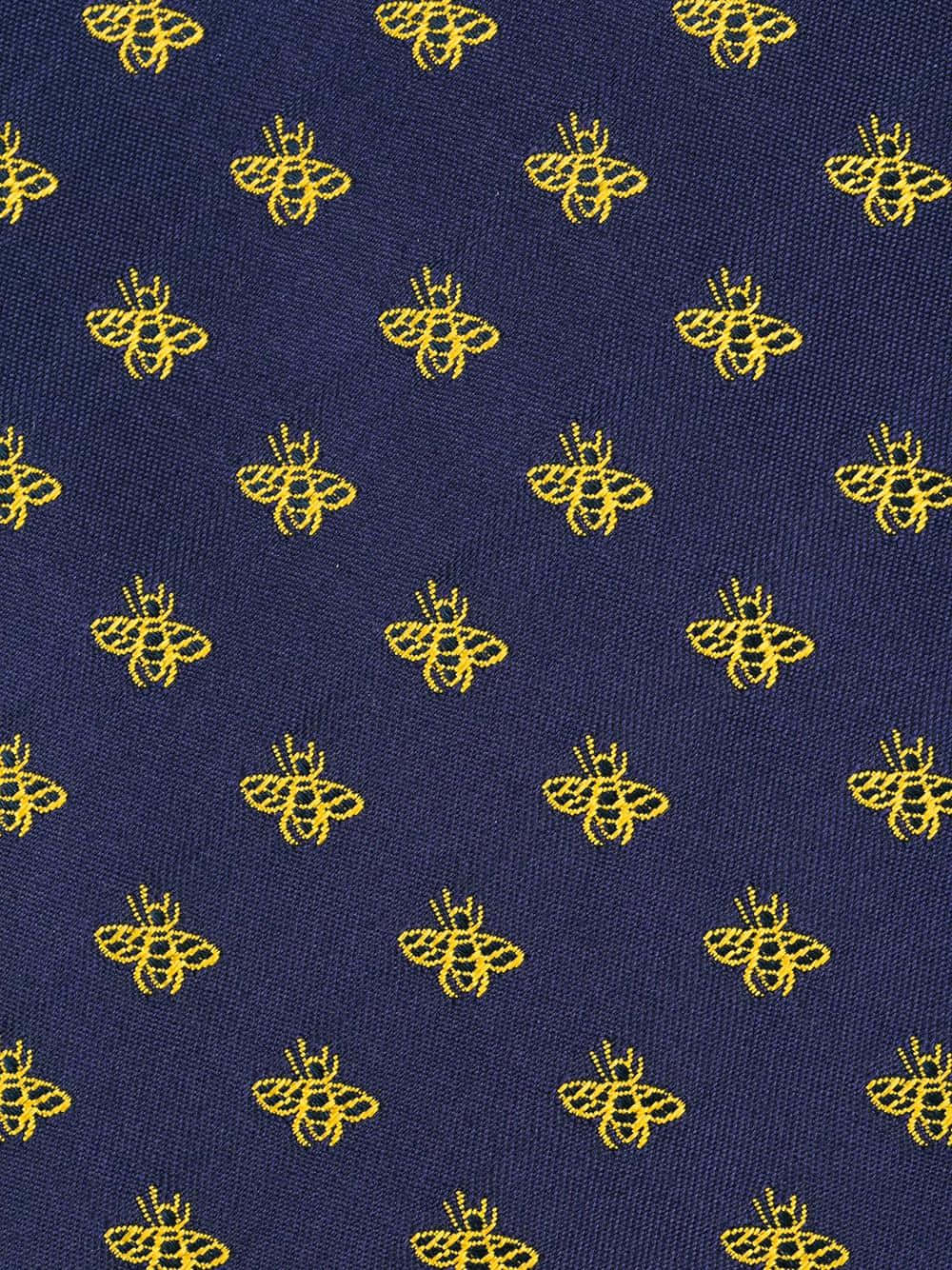 Aesthetic Bee 桌布 壁紙 — 海軍藍布料特寫，整齊網格圖案中重複金色蜜蜂刺繡。