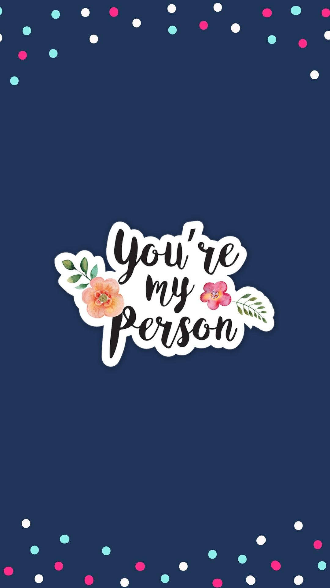 花卉動畫 桌布 壁紙 — 海軍藍色牆紙，白色草書文字寫著「You're my person」，飾有粉紅色和蜜桃色花朵，以及散落的彩色五彩紙屑點。