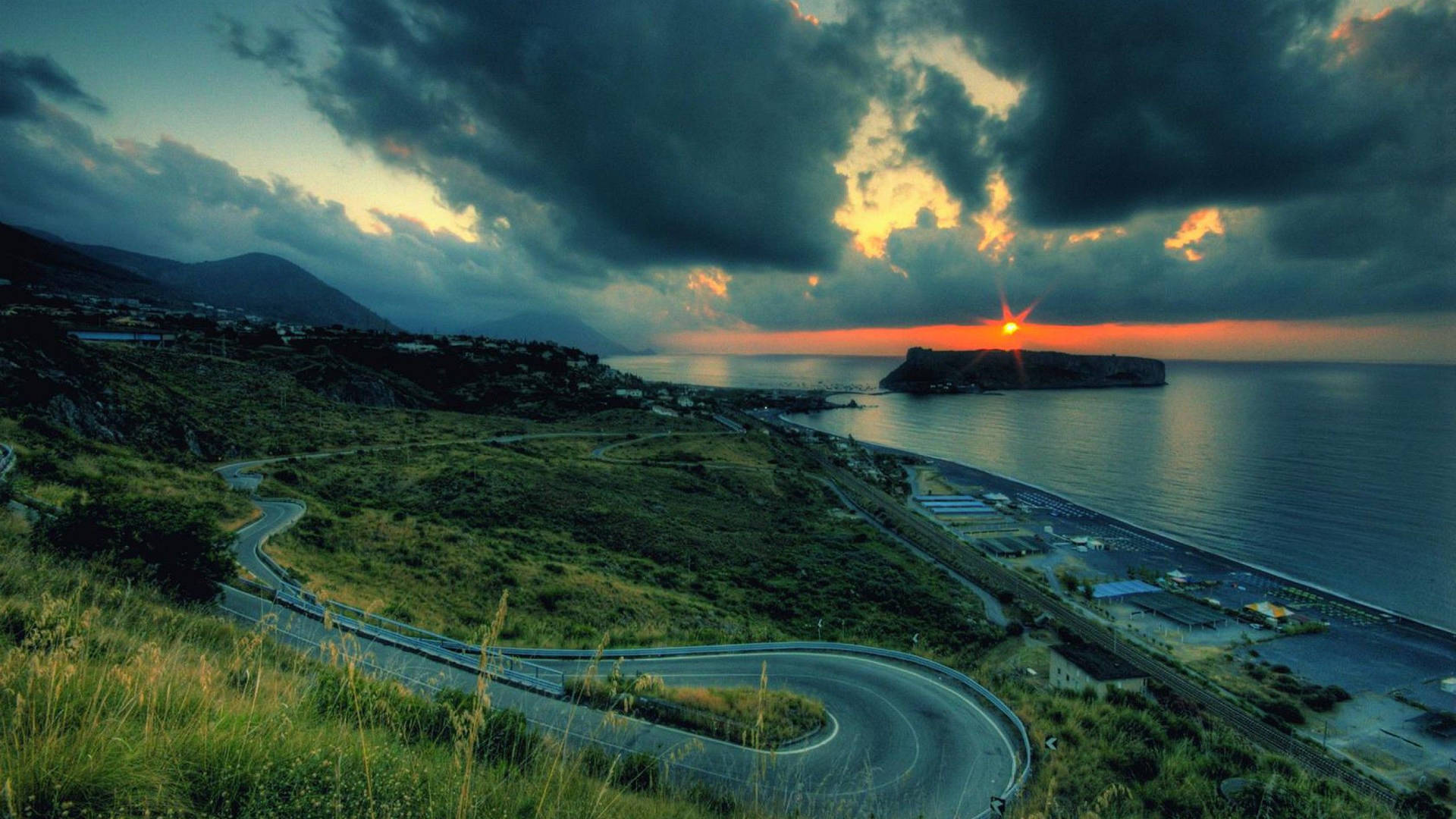 日落時分蜿蜒的海岸公路，有烏雲和大海