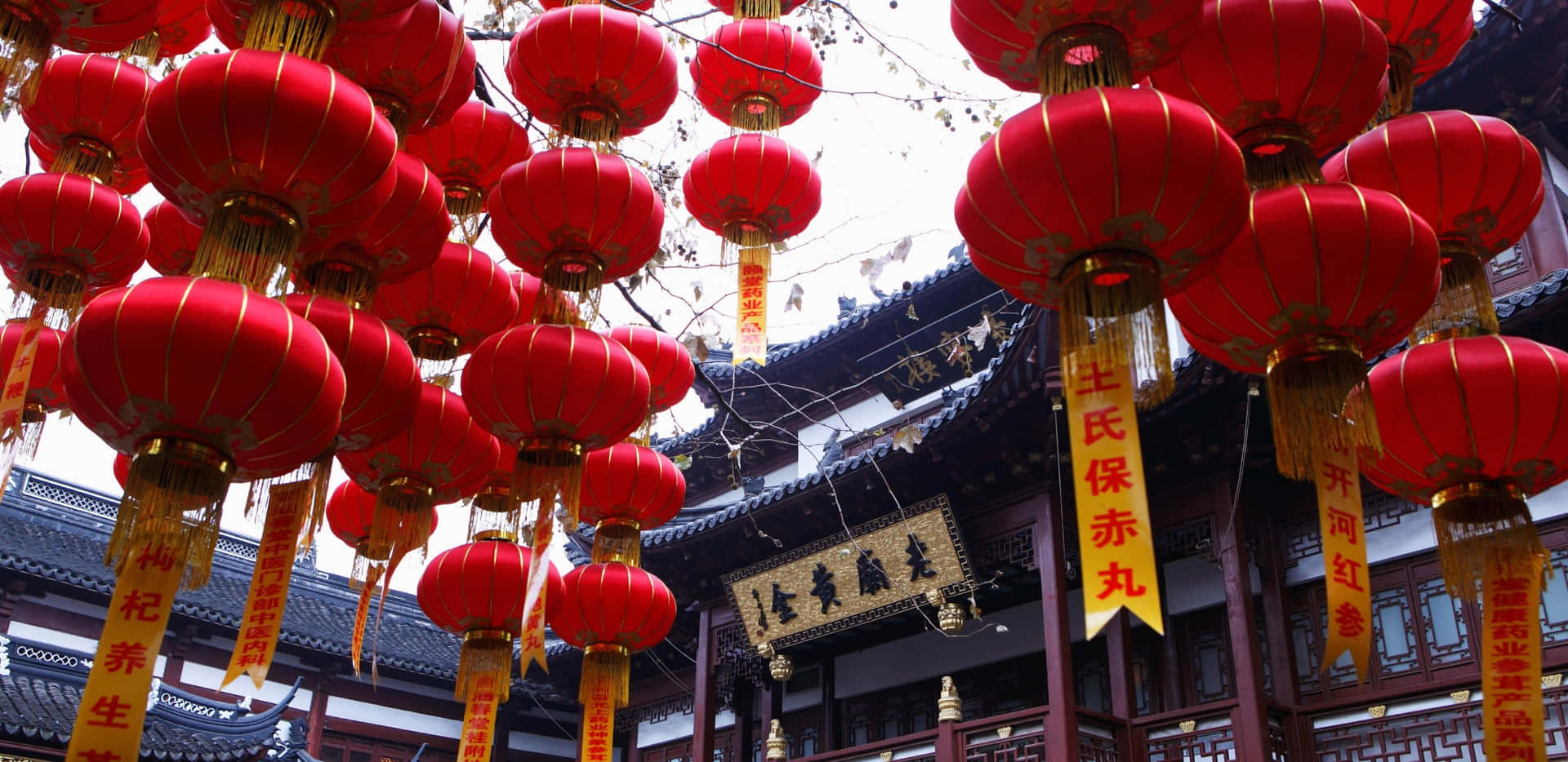 紅色燈籠和金色橫幅裝飾著傳統中式寺廟的入口。