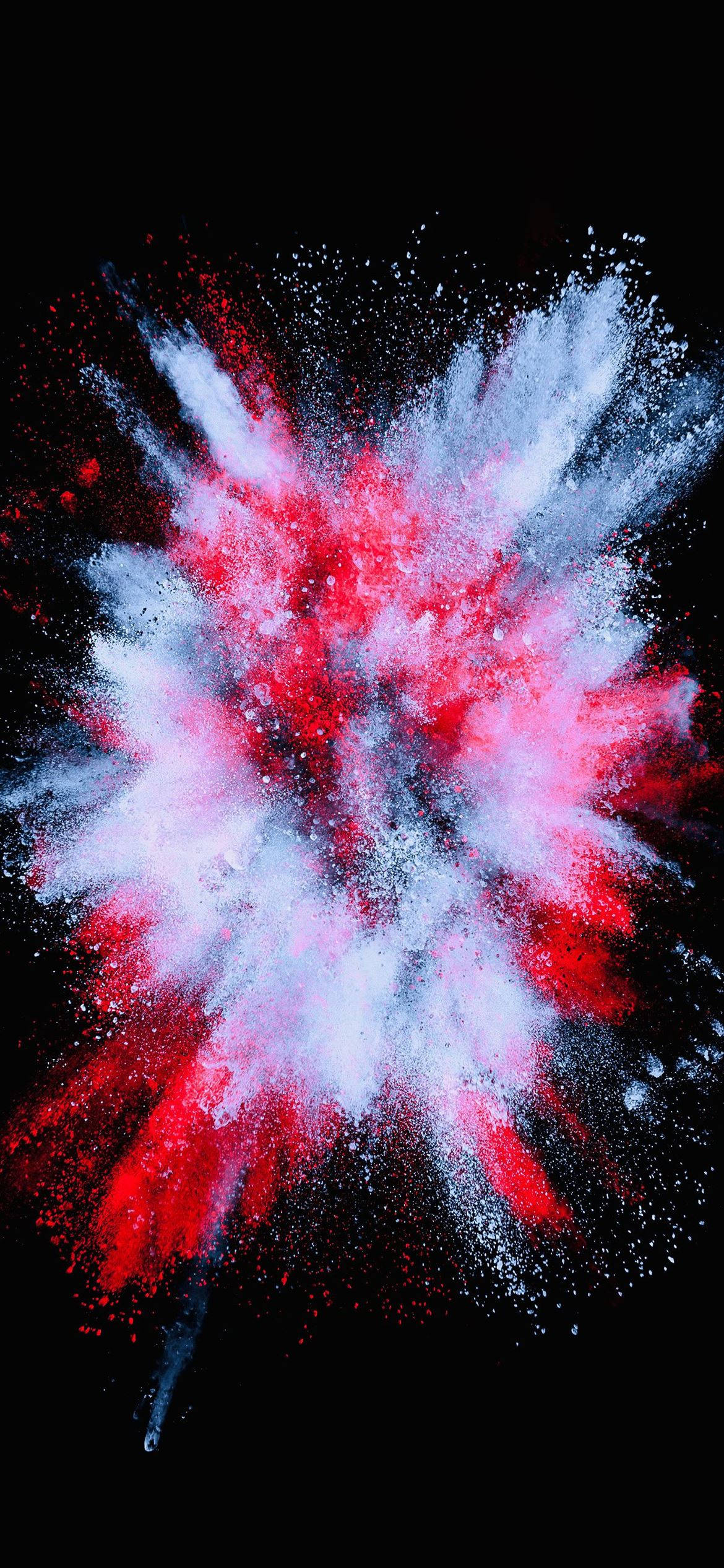 液體爆炸 iPhone 12 壁紙 — 鮮豔的紅色和白色粉末在漆黑的背景上爆炸，形成一個動態的凝固瞬間。