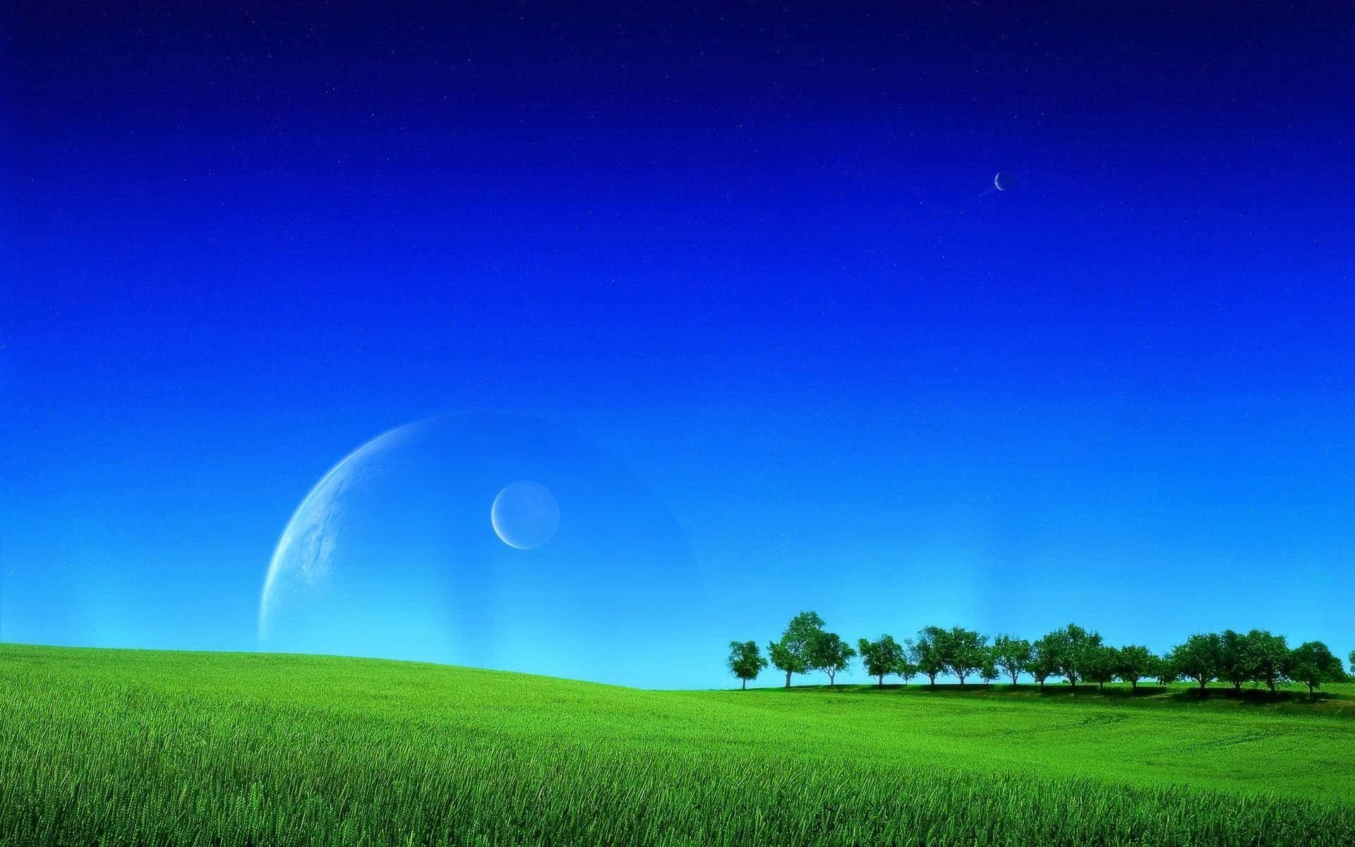 淡月草地與天空背景 壁紙 — 一片充滿活力的綠色田野在深藍色的天空下延伸，地平線上懸掛著一彎新月和一顆巨大的行星。