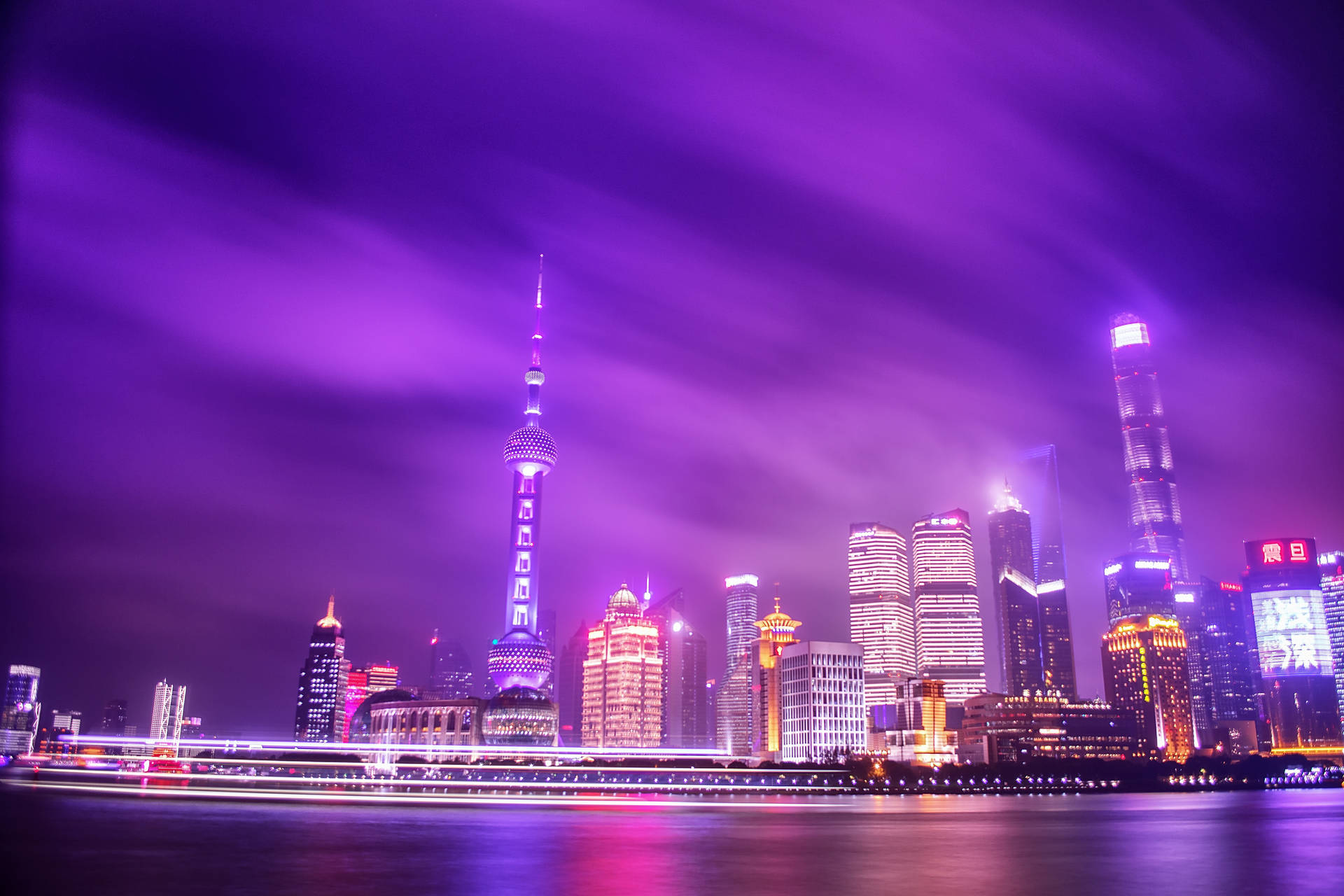 上海夜景，紫色天空，發光建築物倒映在河中。